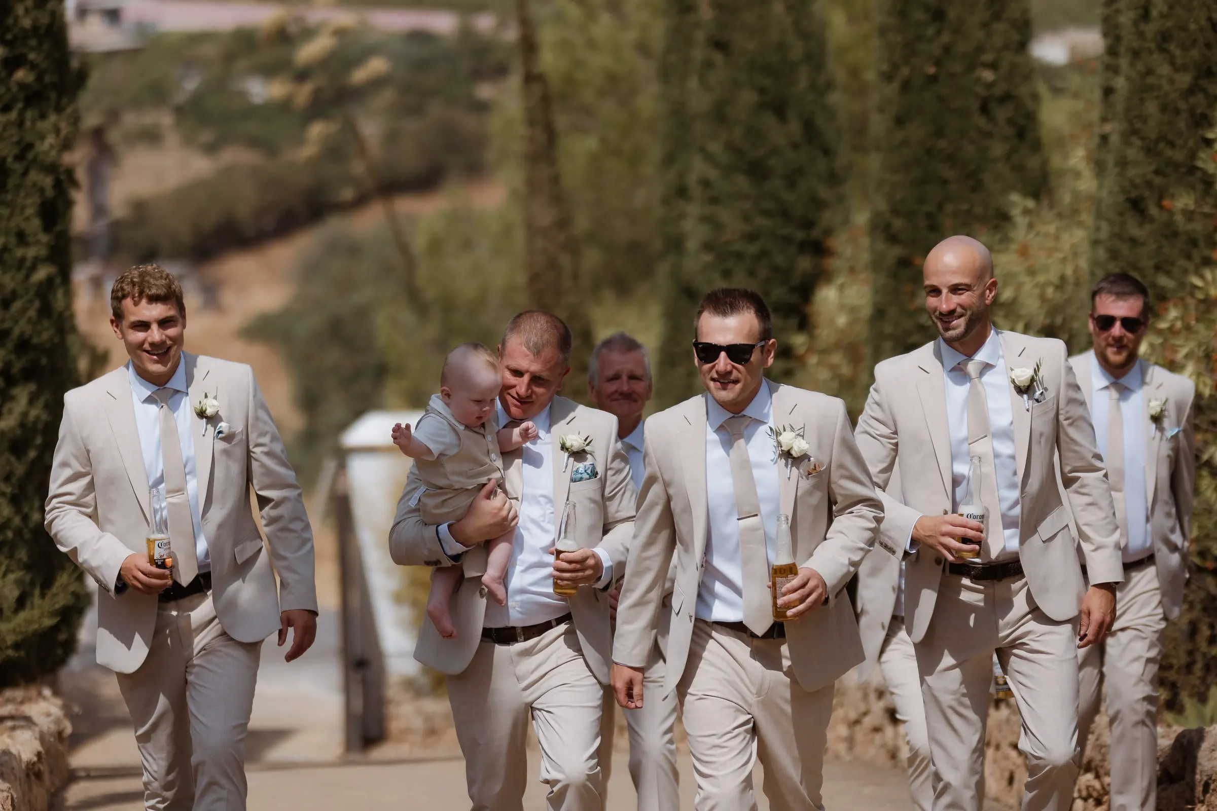 Groom and groomsmen walking down the hill past the cypresses, Mijas