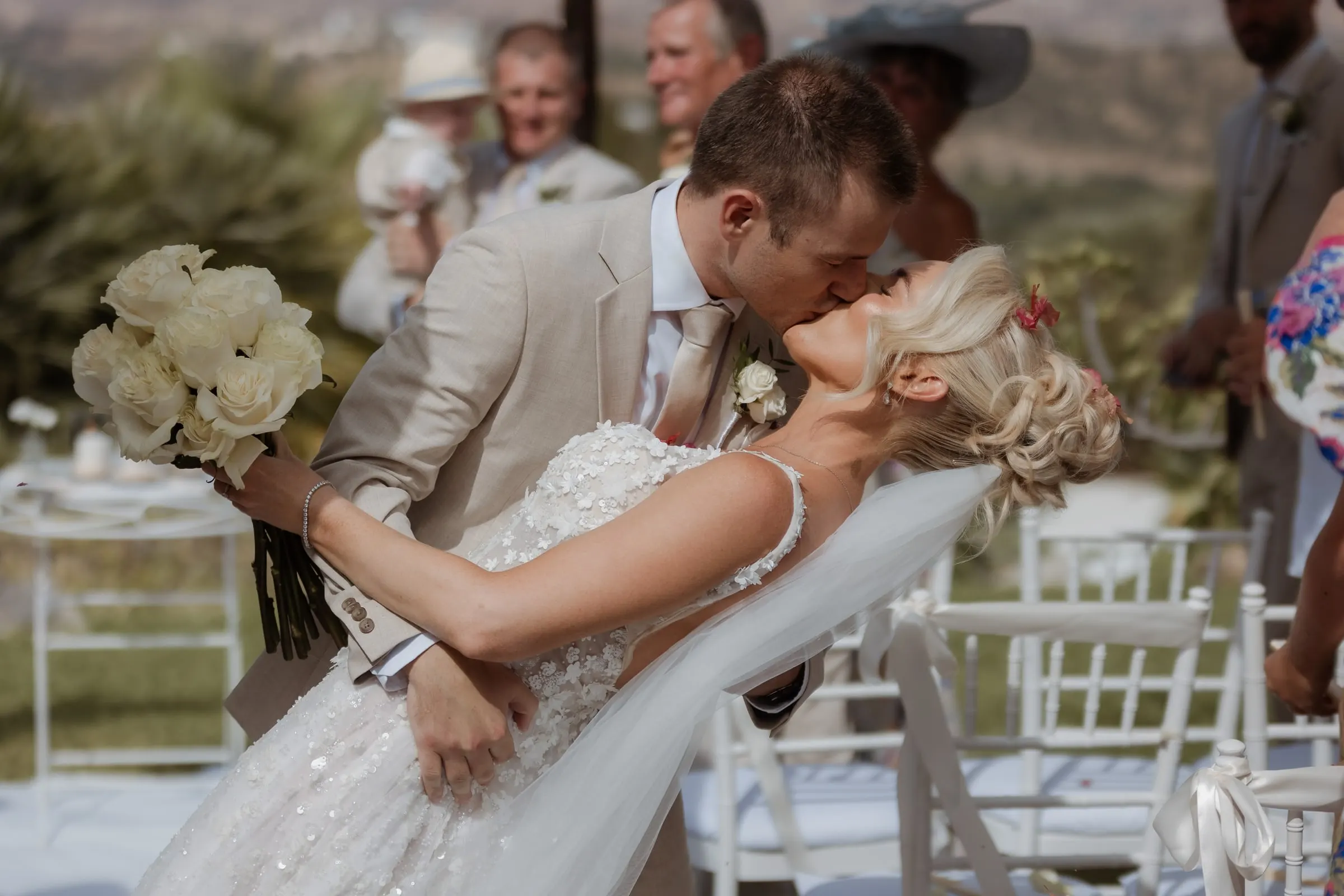 Groom dipping the bride for a kiss among the guests