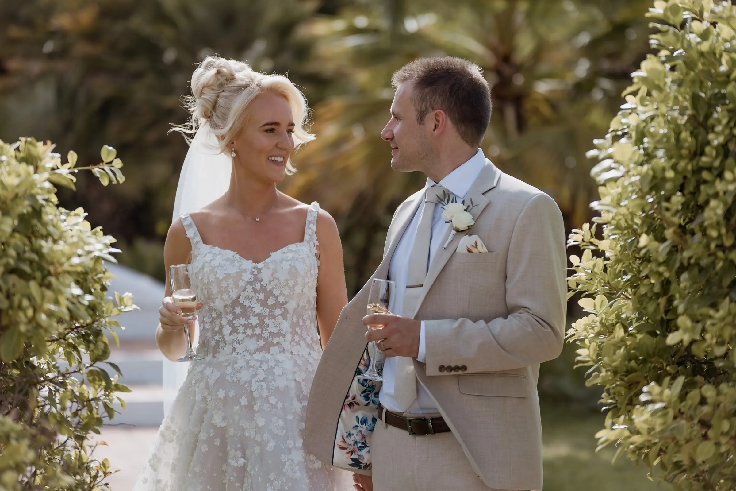 Newlyweds toasting with cava among the green plants of the garden