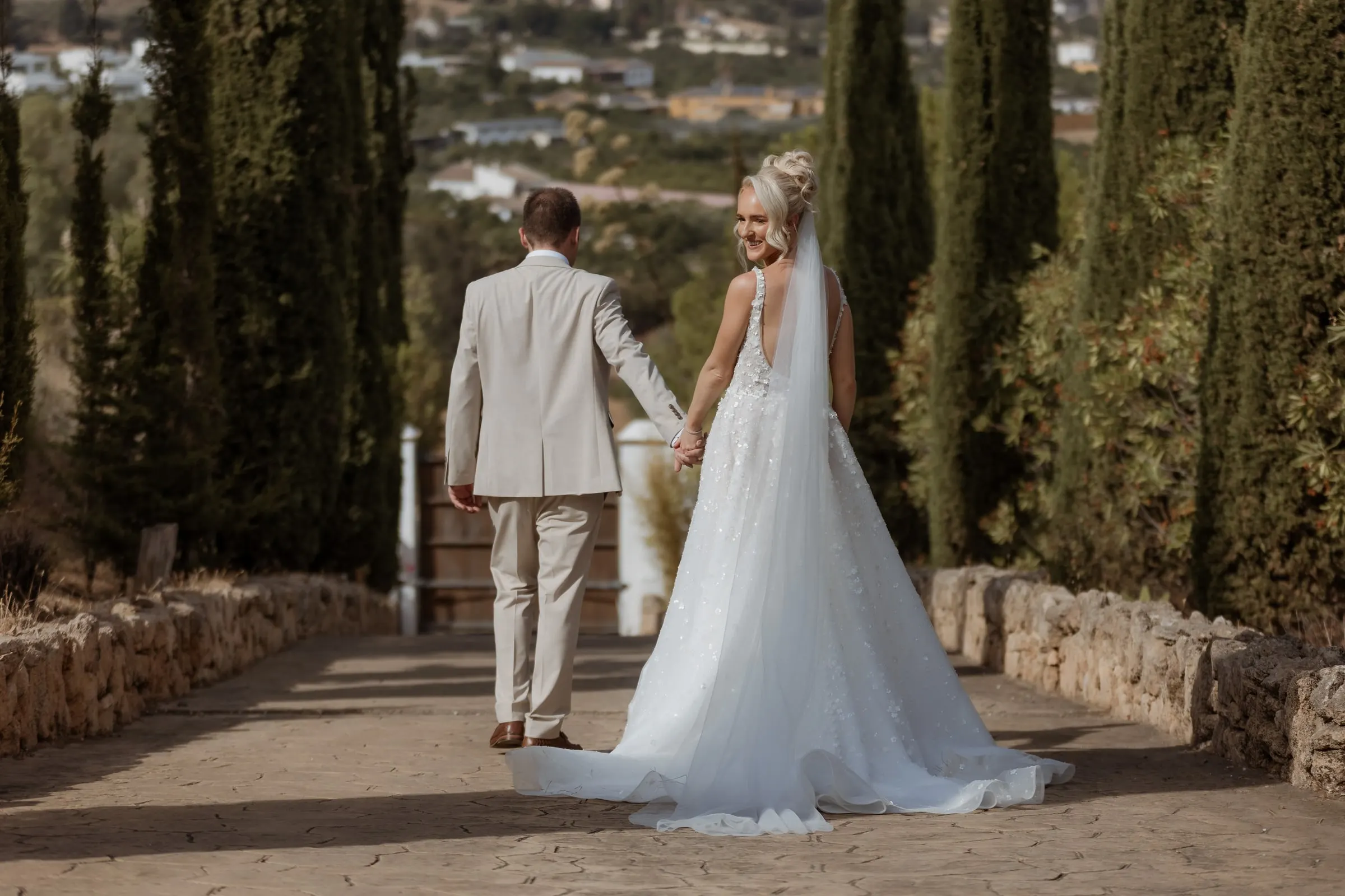Couple walking hand in hand down the cypress avenue above the Mijas valley