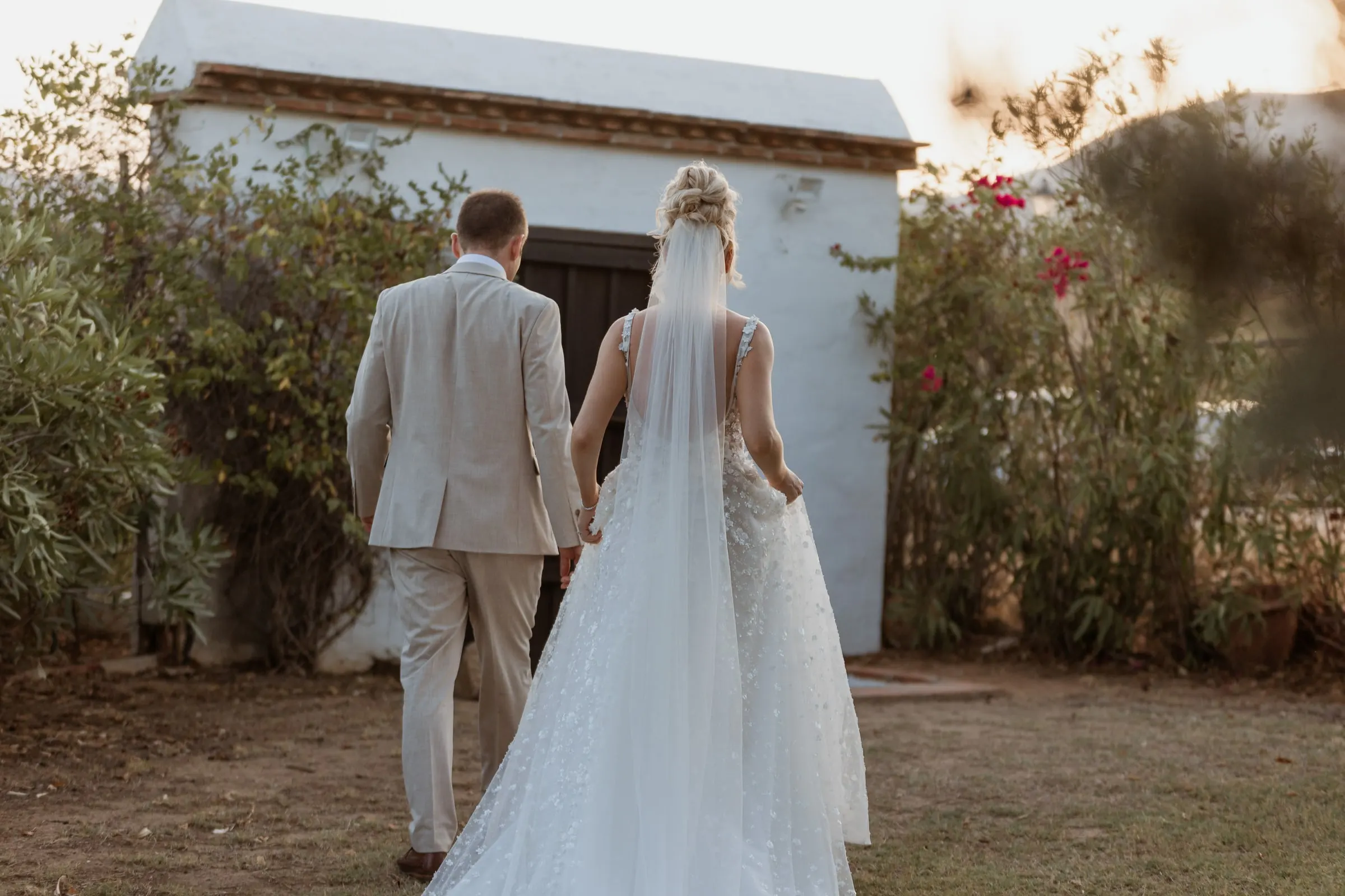Couple walking towards a small whitewashed building in the hacienda grounds