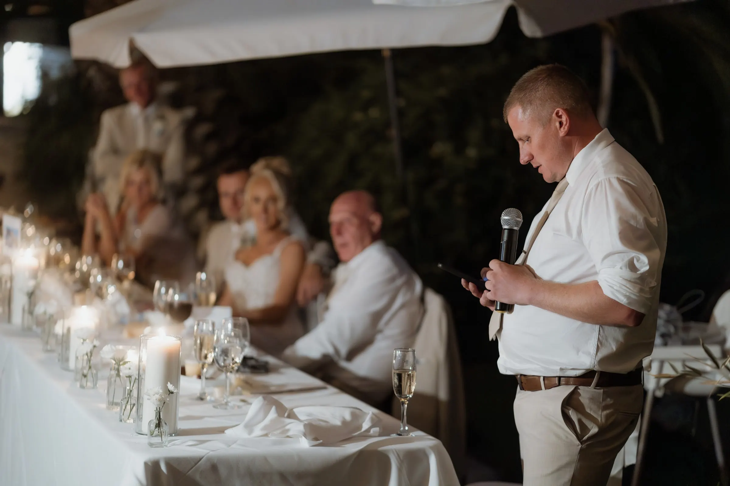 Guest giving a speech with a microphone beside the top table in Mijas