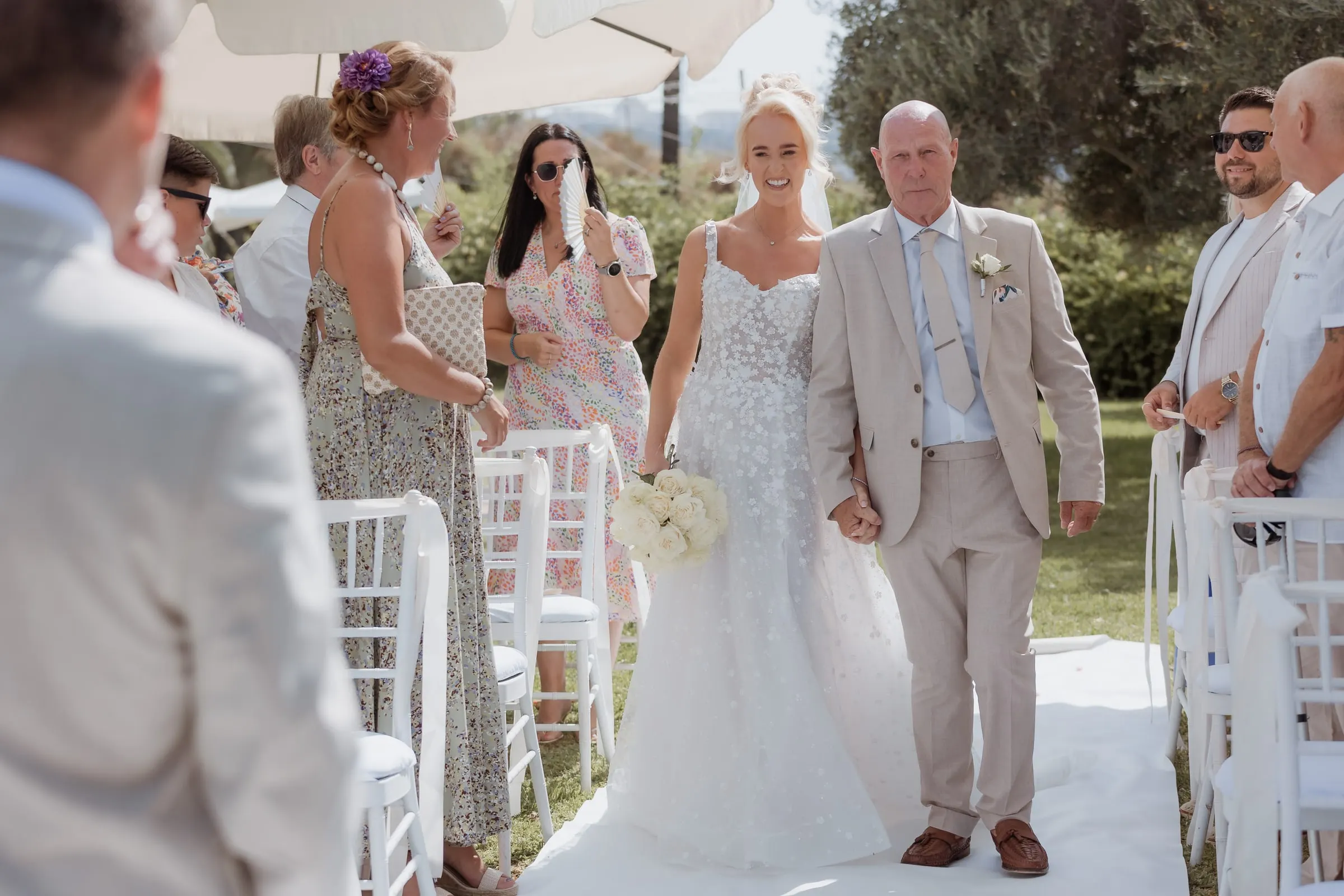 Bride on her father's arm reaching the end of the aisle in the garden, Hacienda San José, Mijas