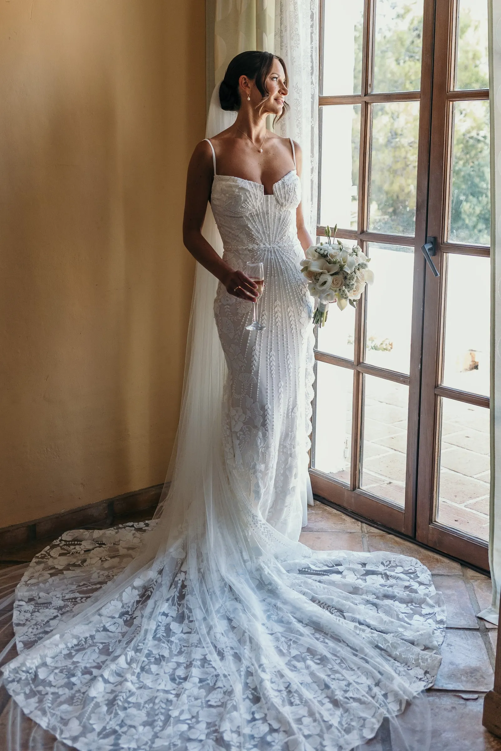 Bride in a lace gown standing by the window, Hacienda San José, Mijas