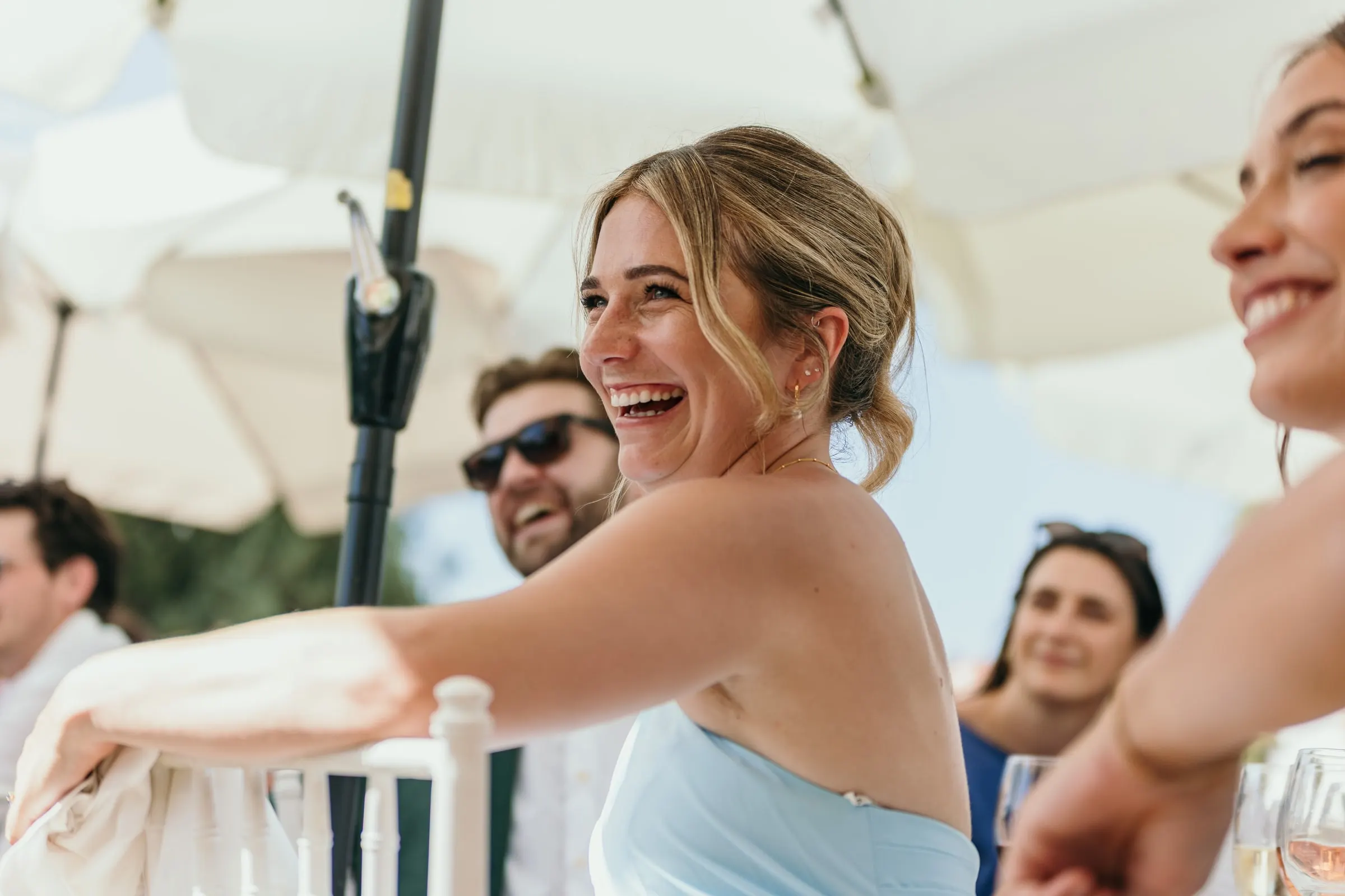 Guest laughing at the reception under white parasols, Hacienda San José