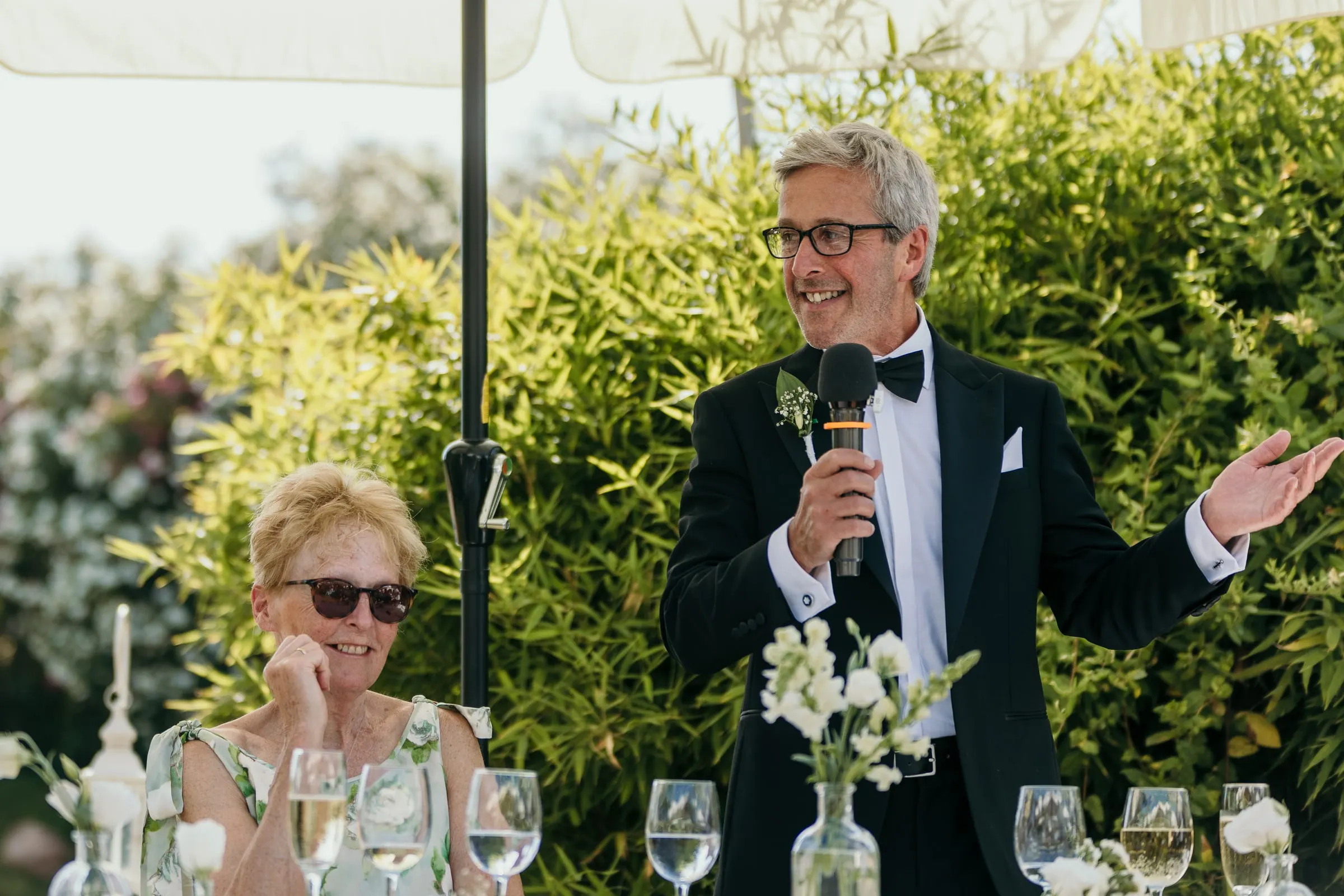 Guest giving a speech with a microphone in the hacienda garden