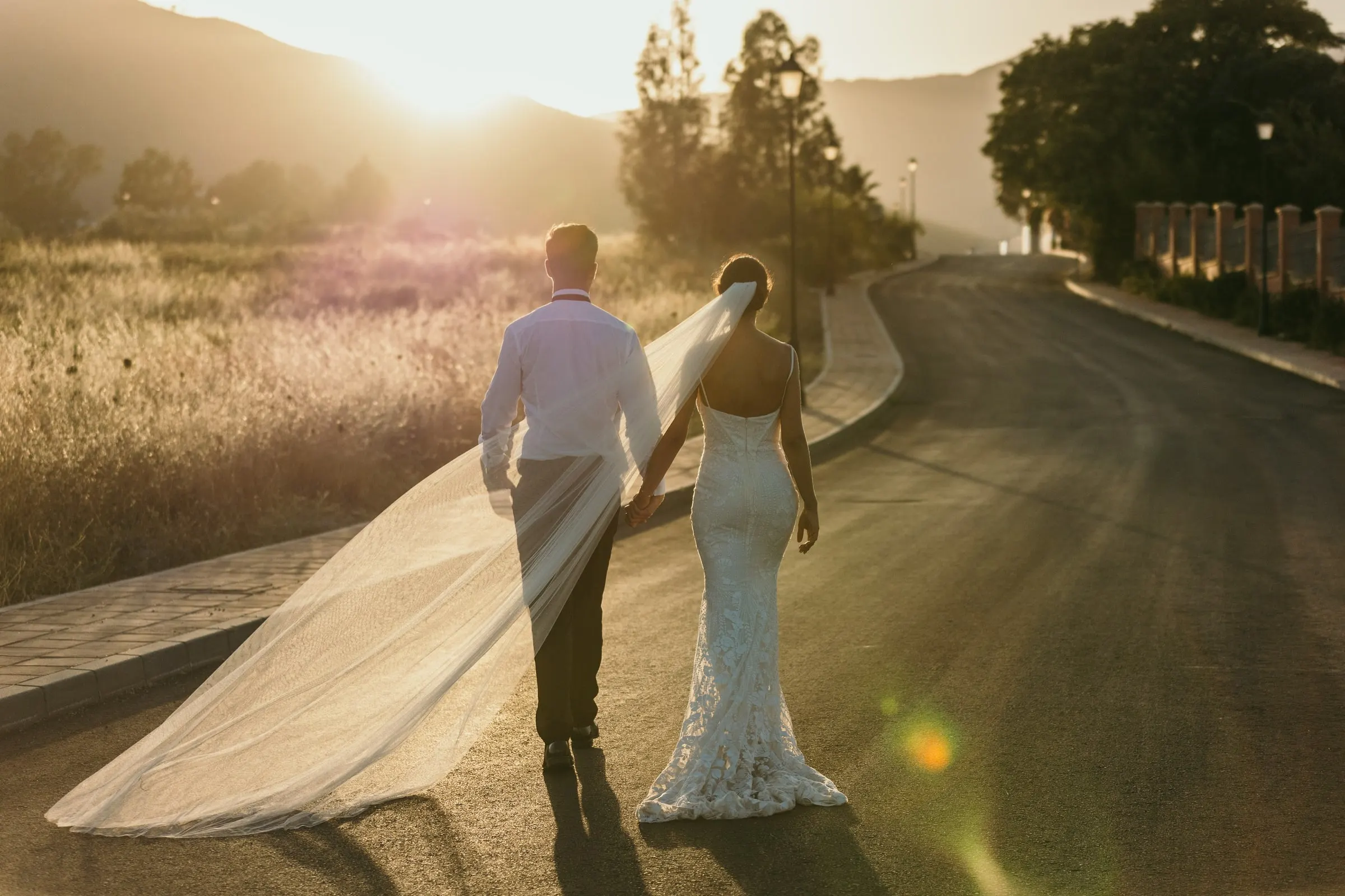 Couple walking hand in hand along a country lane at golden hour in Mijas