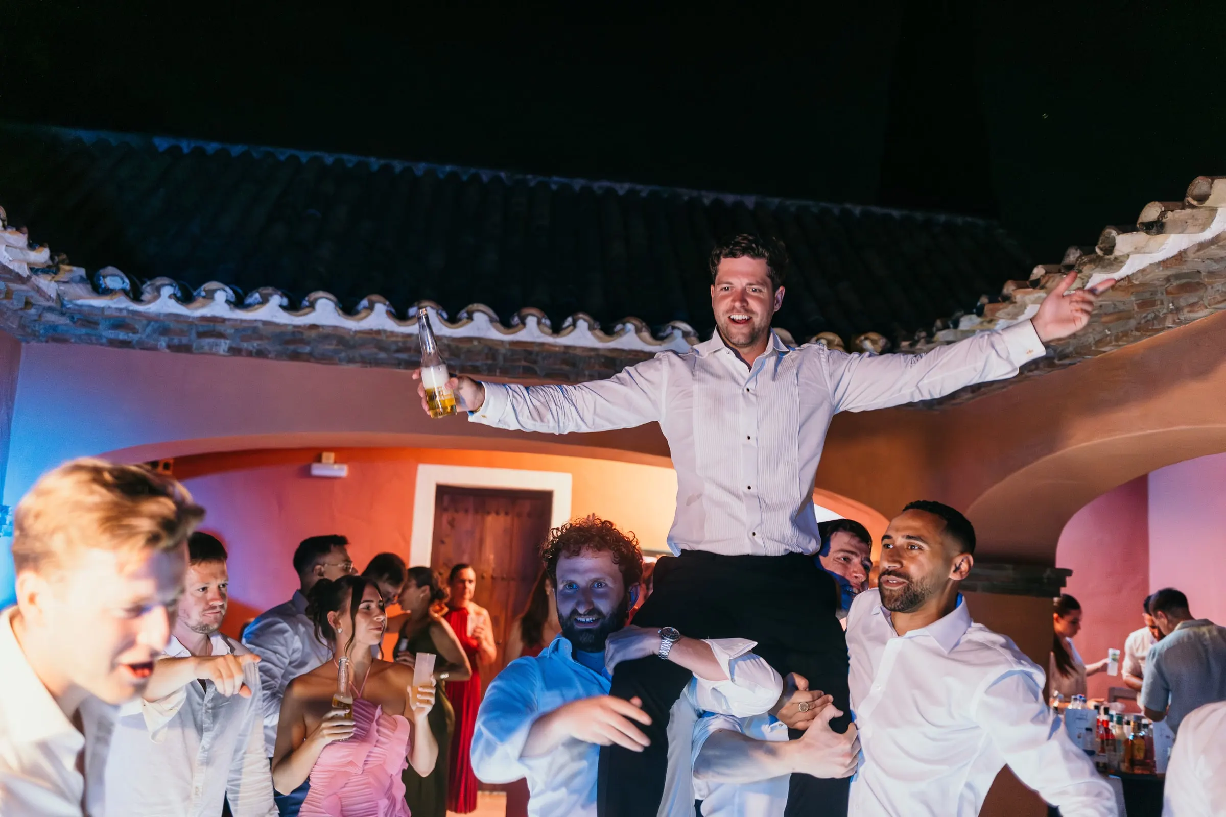 Groom lifted into the air by his friends on the dance floor