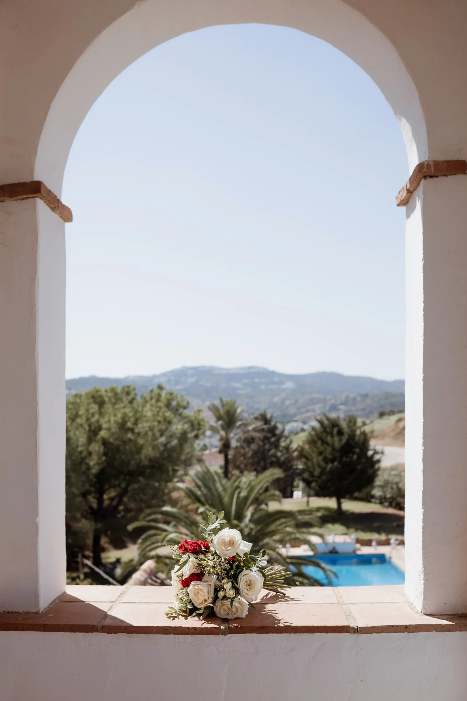 The bridal bouquet on a whitewashed arched window overlooking the pool and hills, Hacienda San José, Mijas