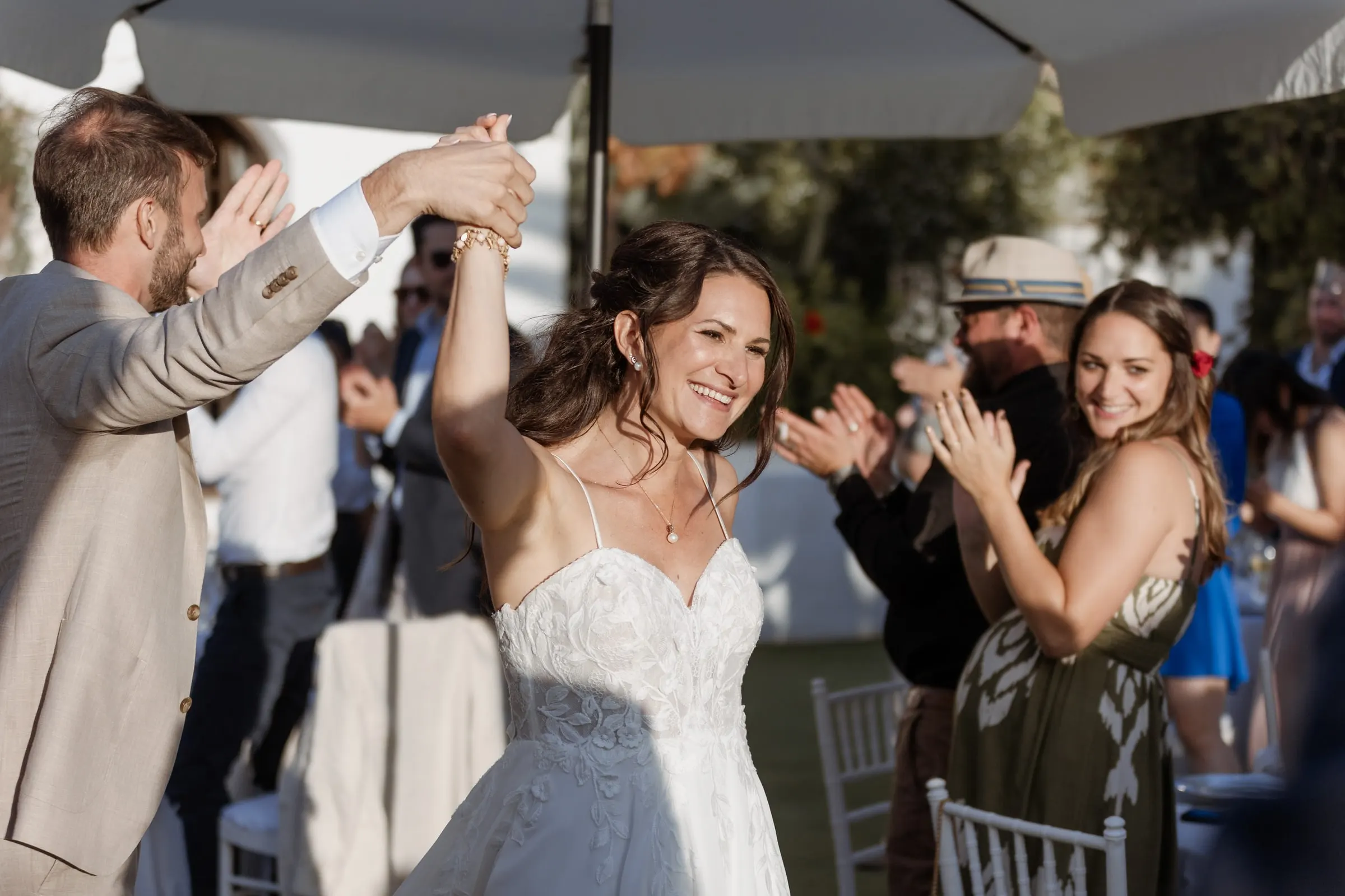 The groom twirling the bride as guests clap around them in the garden, Hacienda San José, Mijas