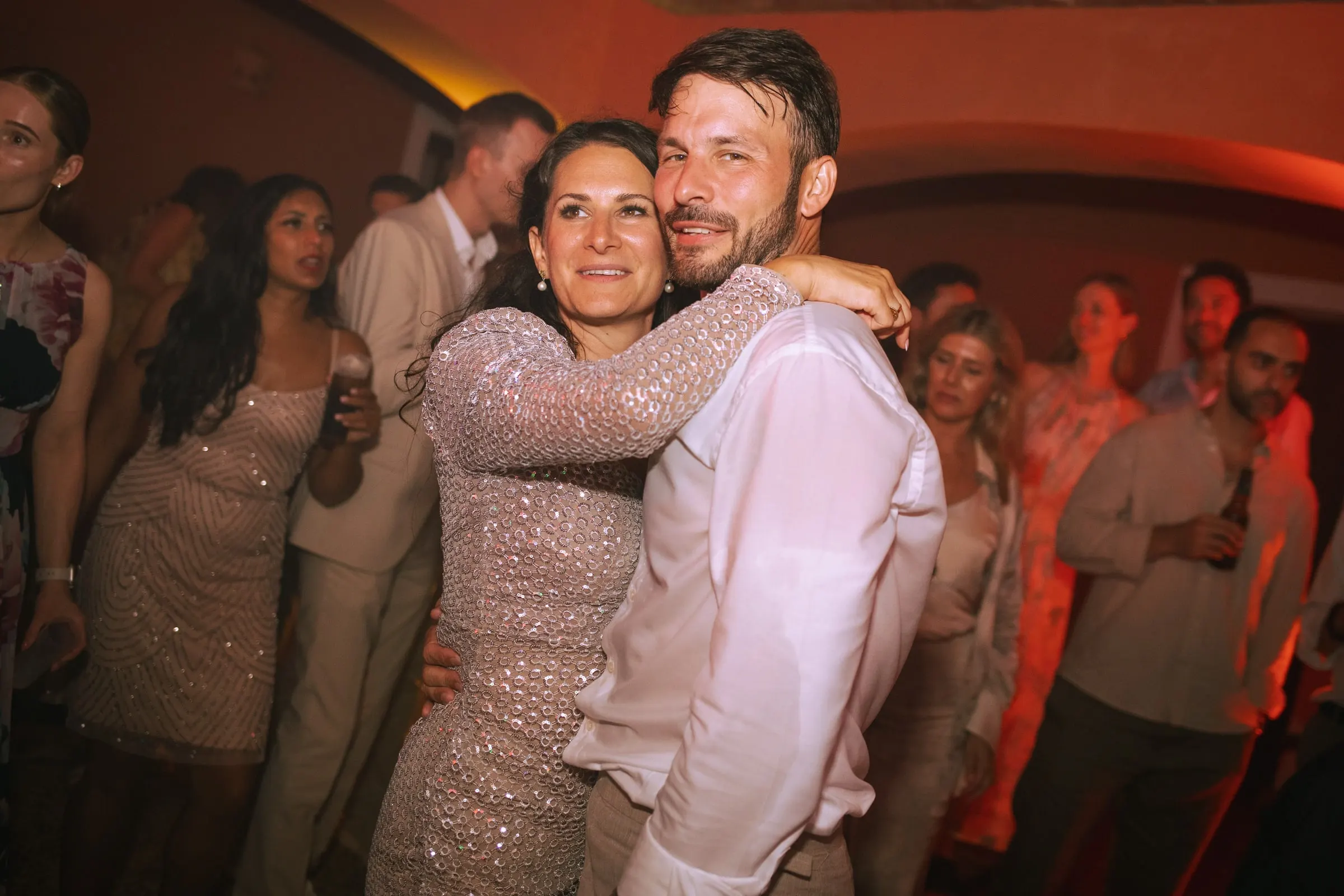 The groom dancing cheek to cheek with a guest in a sequinned dress at the party, Hacienda San José, Mijas
