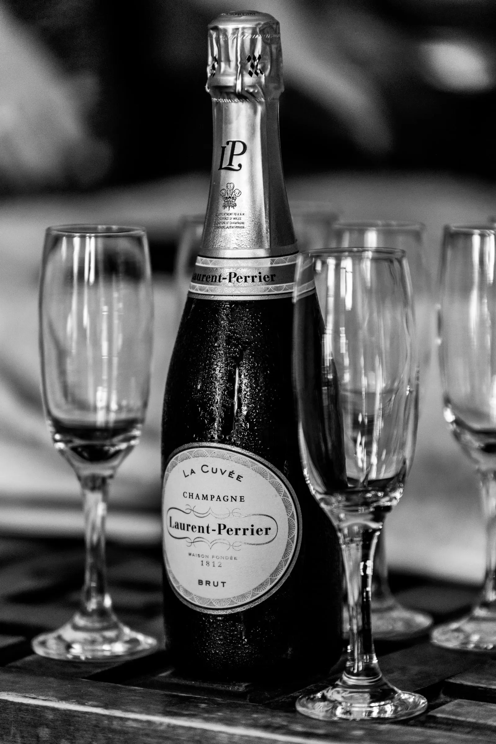 Black and white of a champagne bottle surrounded by empty flutes ready for the toast, Hacienda San José, Mijas
