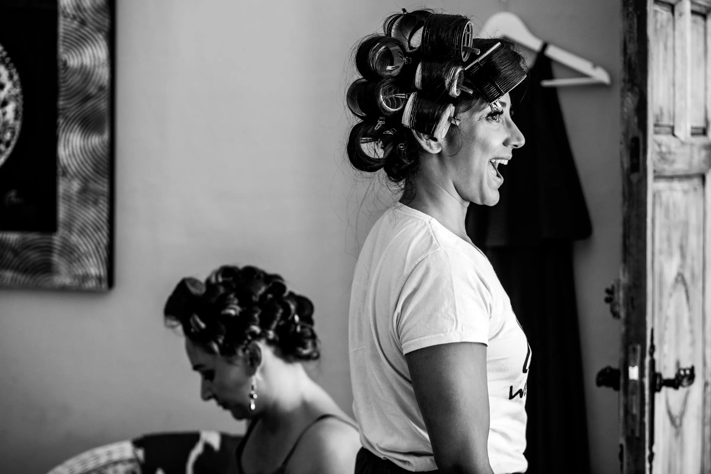 Black and white of two women in hair rollers laughing as they get ready, Hacienda San José, Mijas