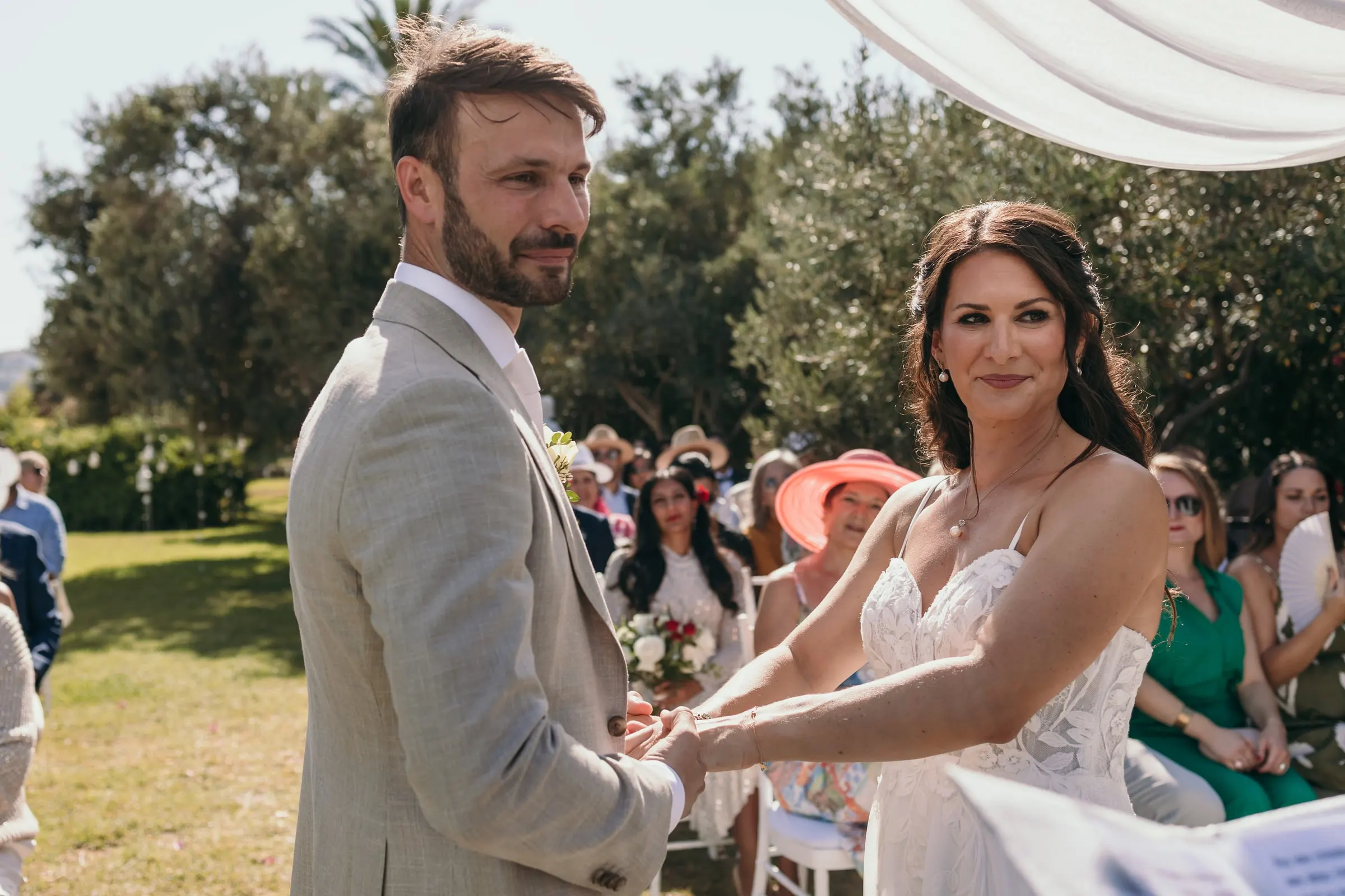 The couple holding hands during the vows as guests look on from their seats, Hacienda San José, Mijas