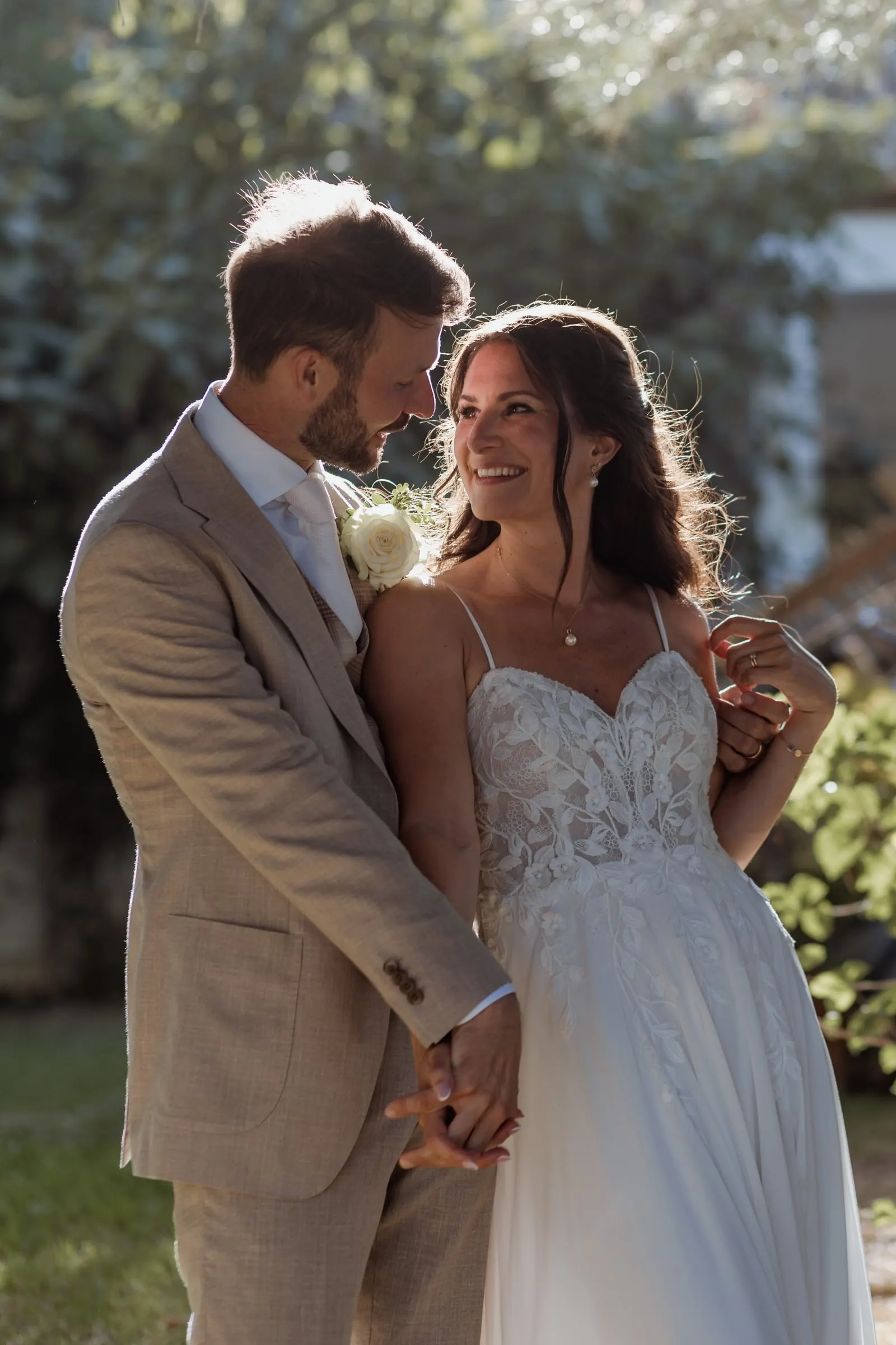 The groom resting his head against the bride's as they smile in a sunny garden, Hacienda San José, Mijas