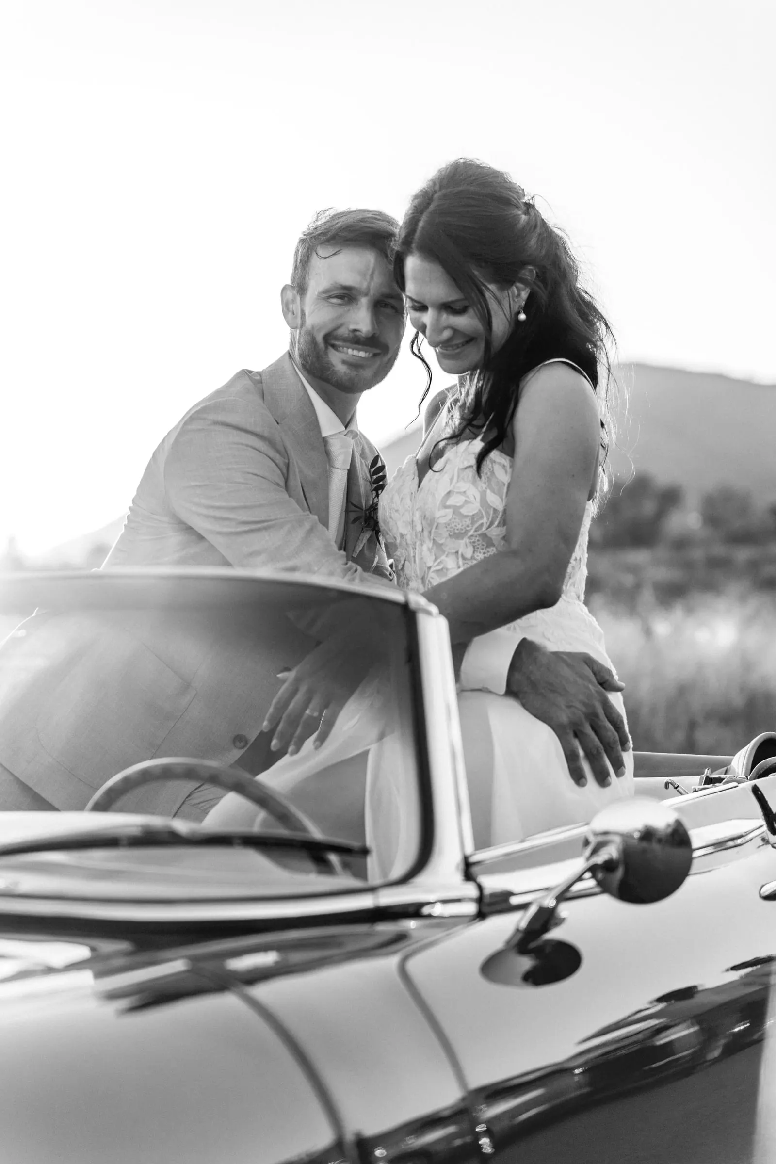 Black and white of the couple smiling together in a convertible, the groom at the wheel, Hacienda San José, Mijas