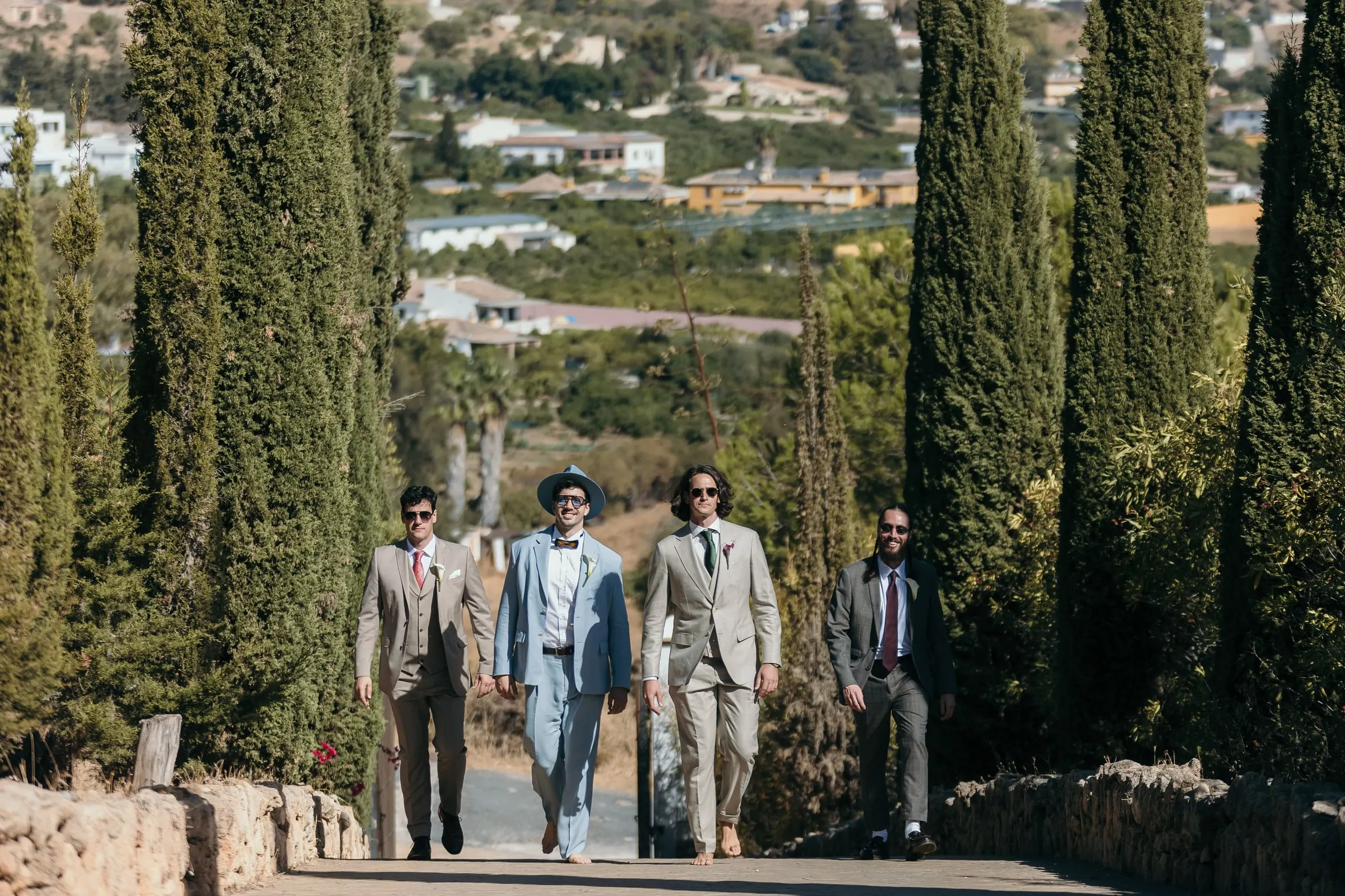 The groom and three friends walking down the cypress-lined drive, Hacienda San José, Mijas