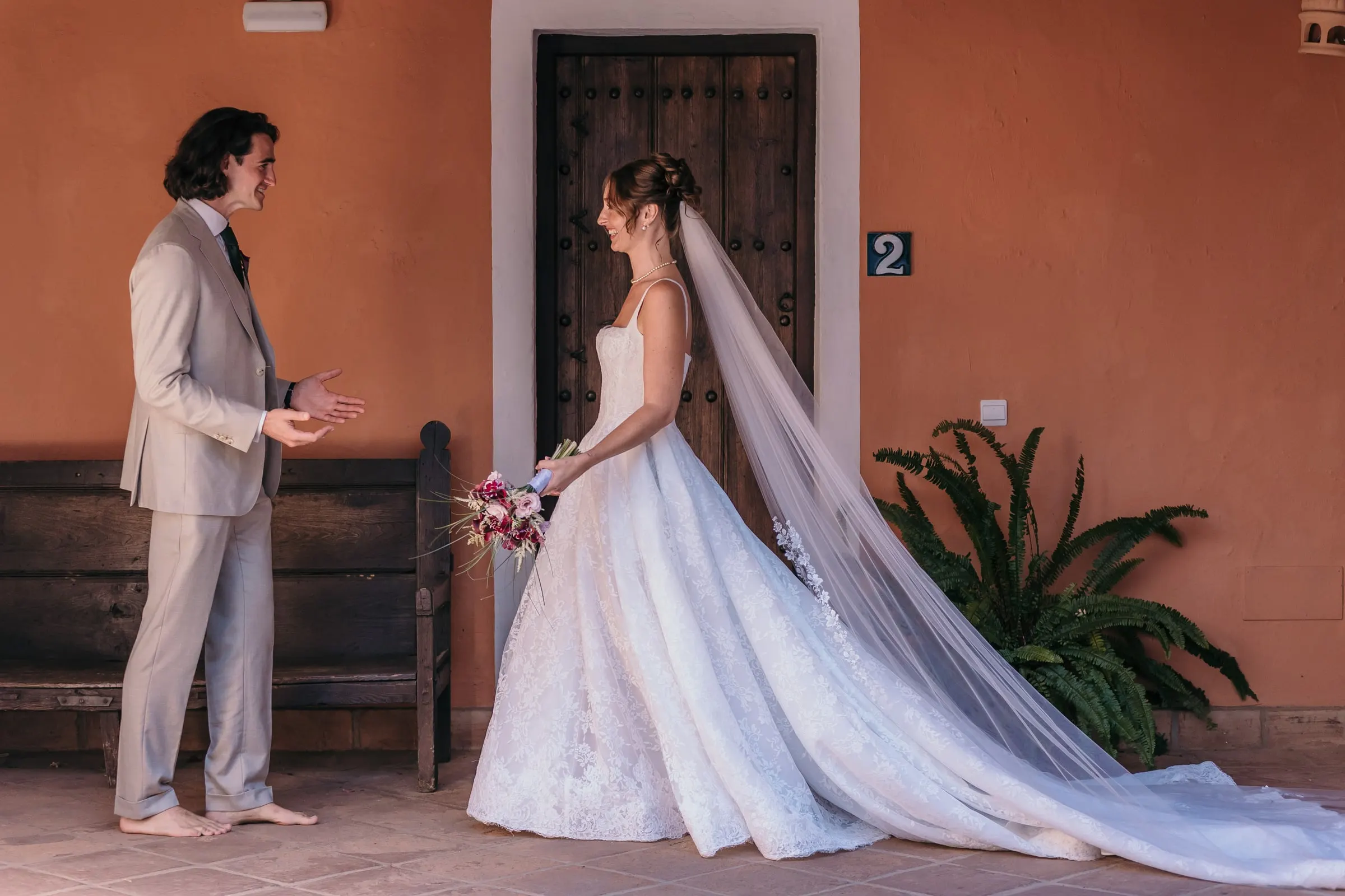 The first look: the groom turning to see the bride in a terracotta porch, Hacienda San José, Mijas