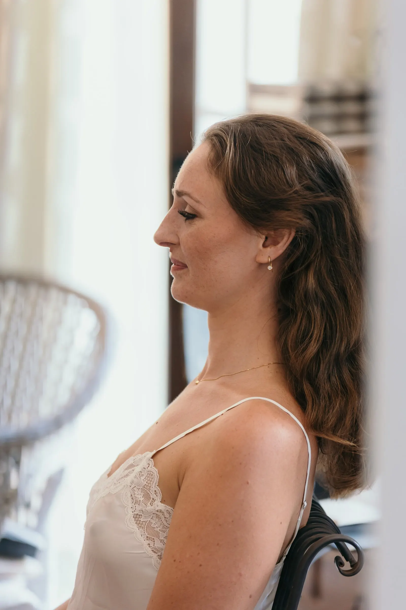 Profile of the bride in a lace slip, eyes lowered, as she gets ready, Hacienda San José, Mijas