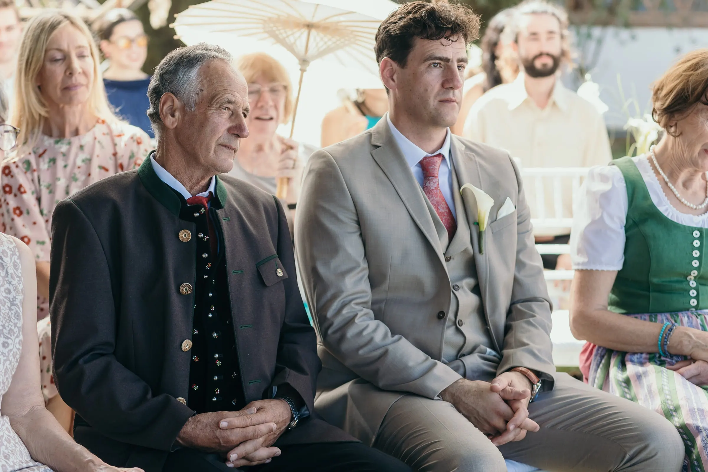 Guests at the ceremony, an older man in a traditional jacket beside a woman in a dirndl, Hacienda San José, Mijas