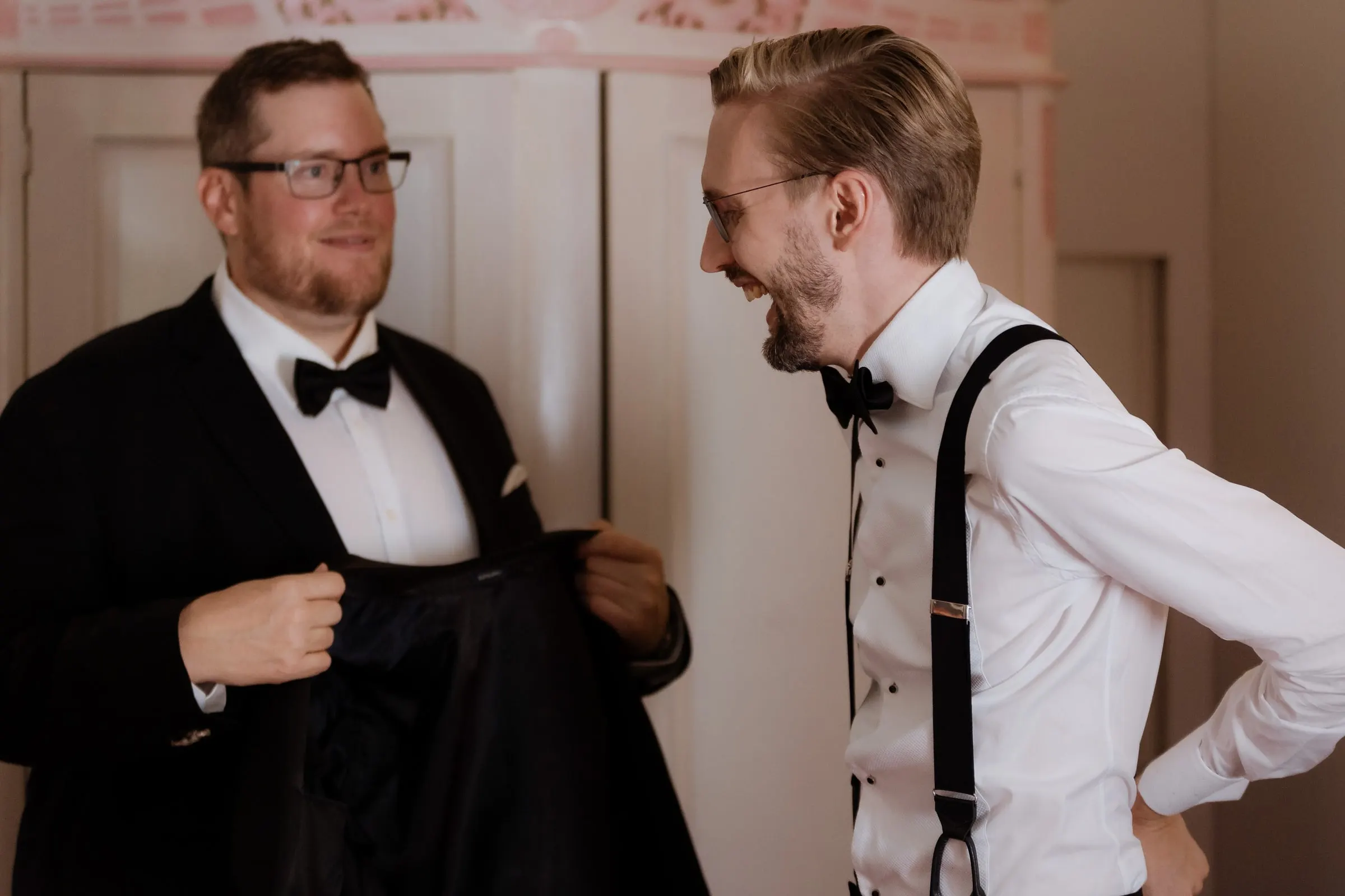 Friend helping the groom into his tuxedo jacket on the wedding morning in Ronda