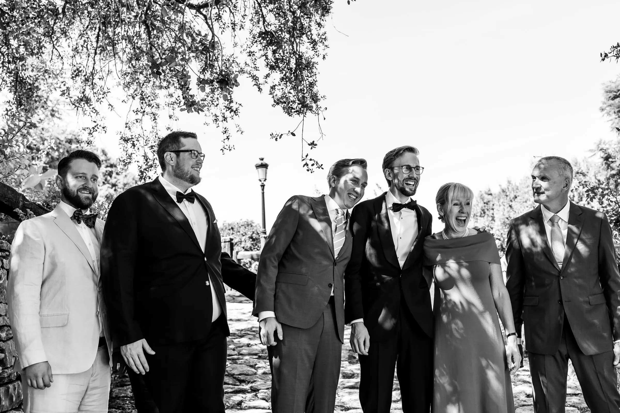 Black and white portrait of the groom with his groomsmen and family on a sunny path in Ronda