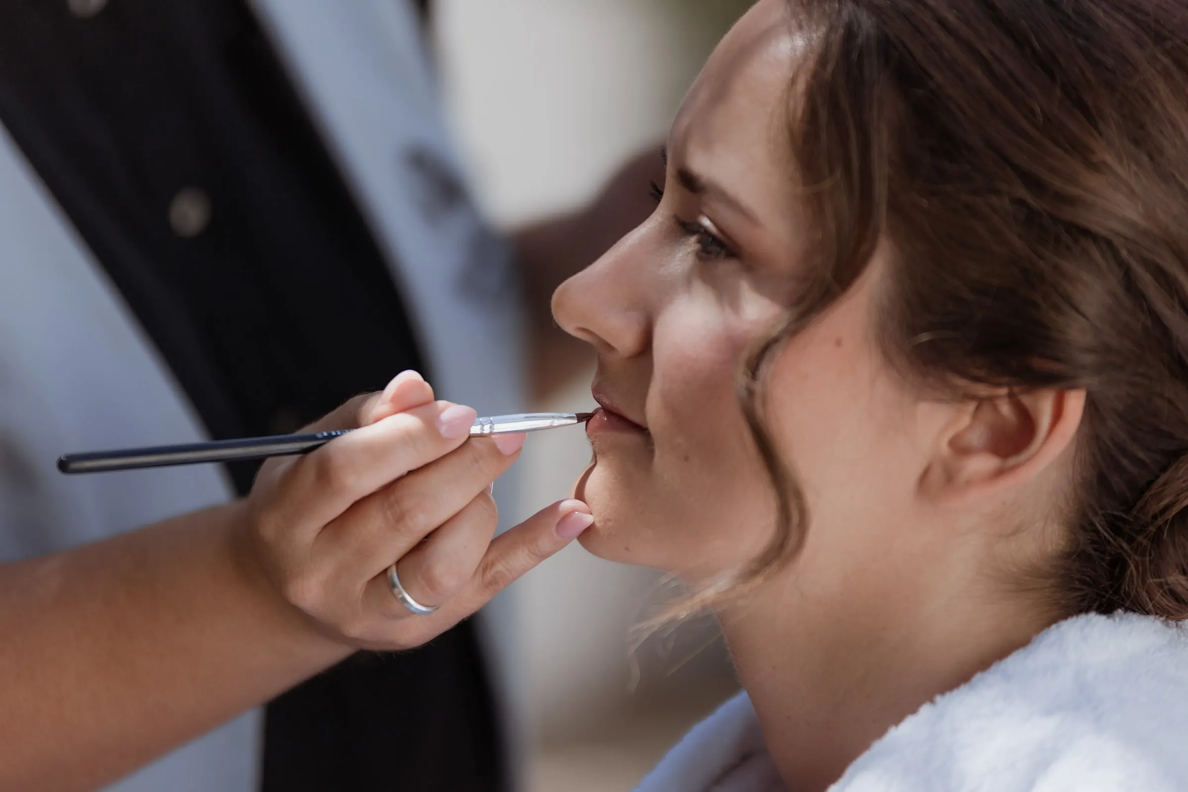 Make-up artist applying the bride's lipstick before her wedding in Ronda
