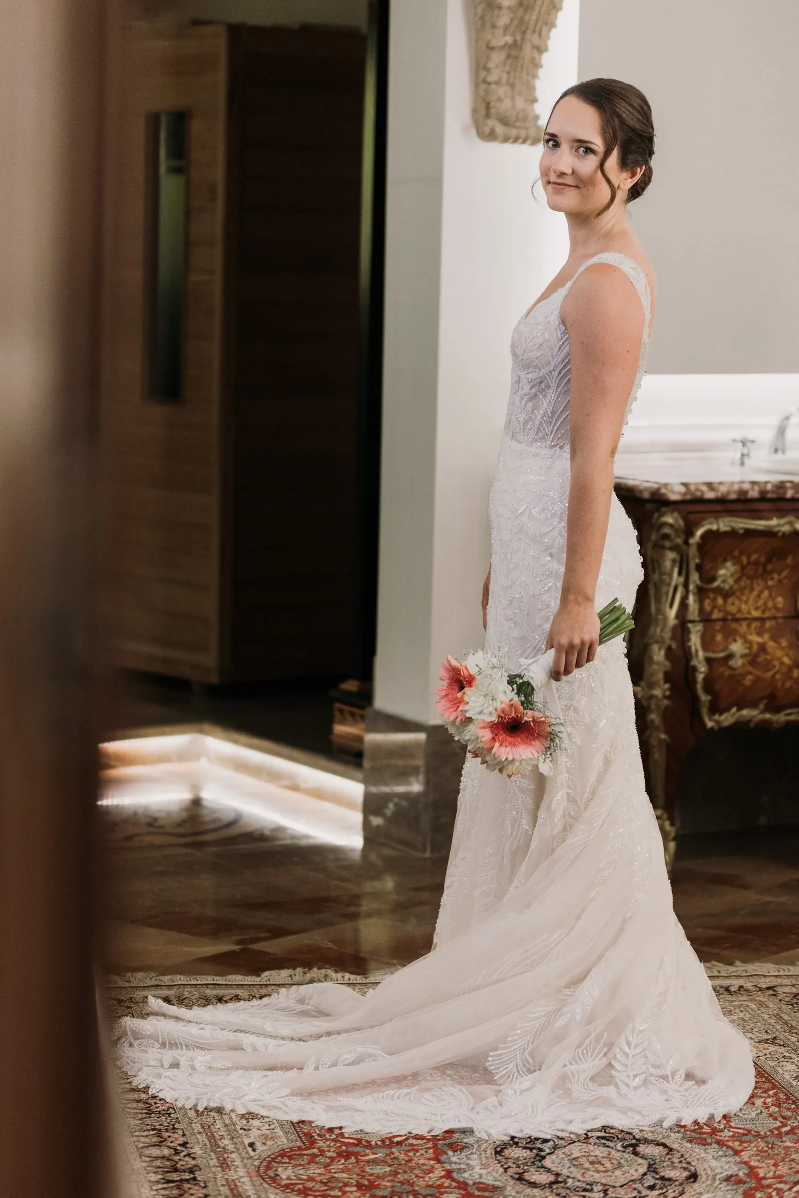 Bride turning to smile over her shoulder, bouquet in hand, at Los Pilares de Ronda