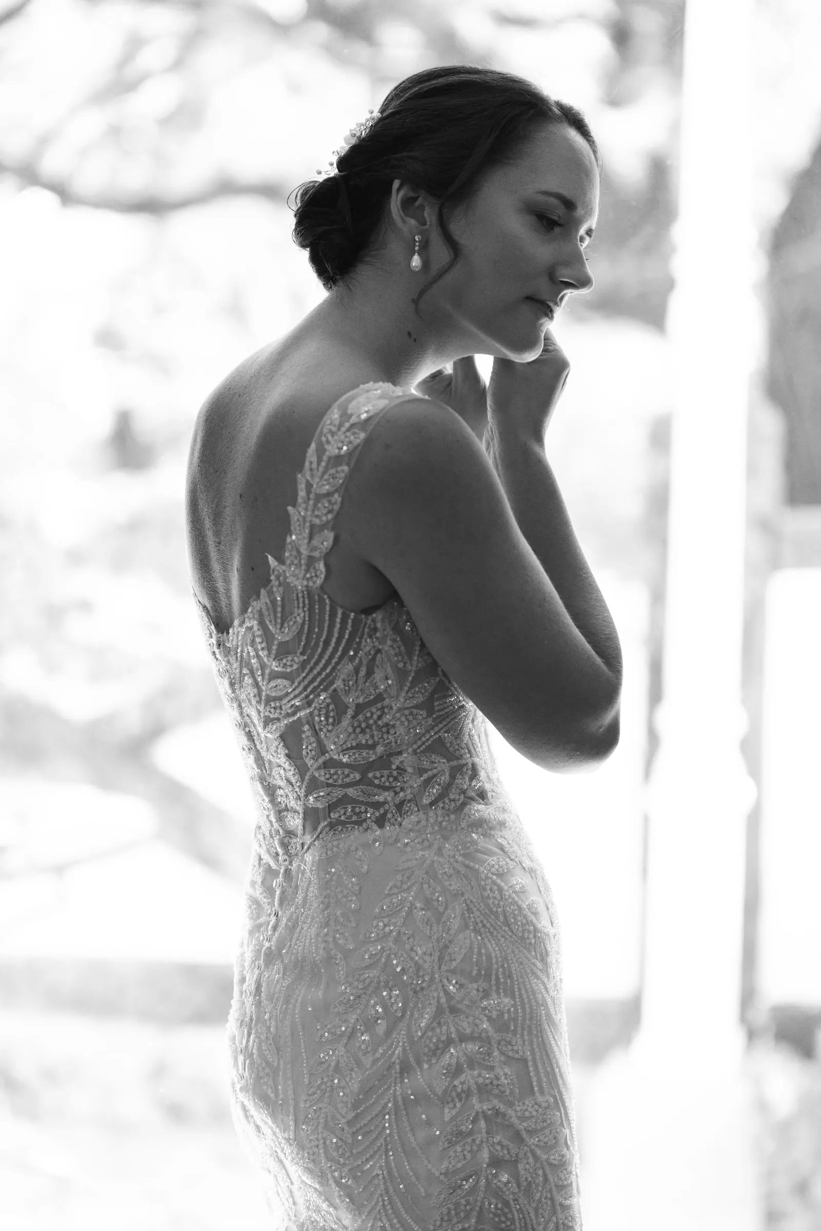 Black and white profile of the bride showing the lace back of her dress