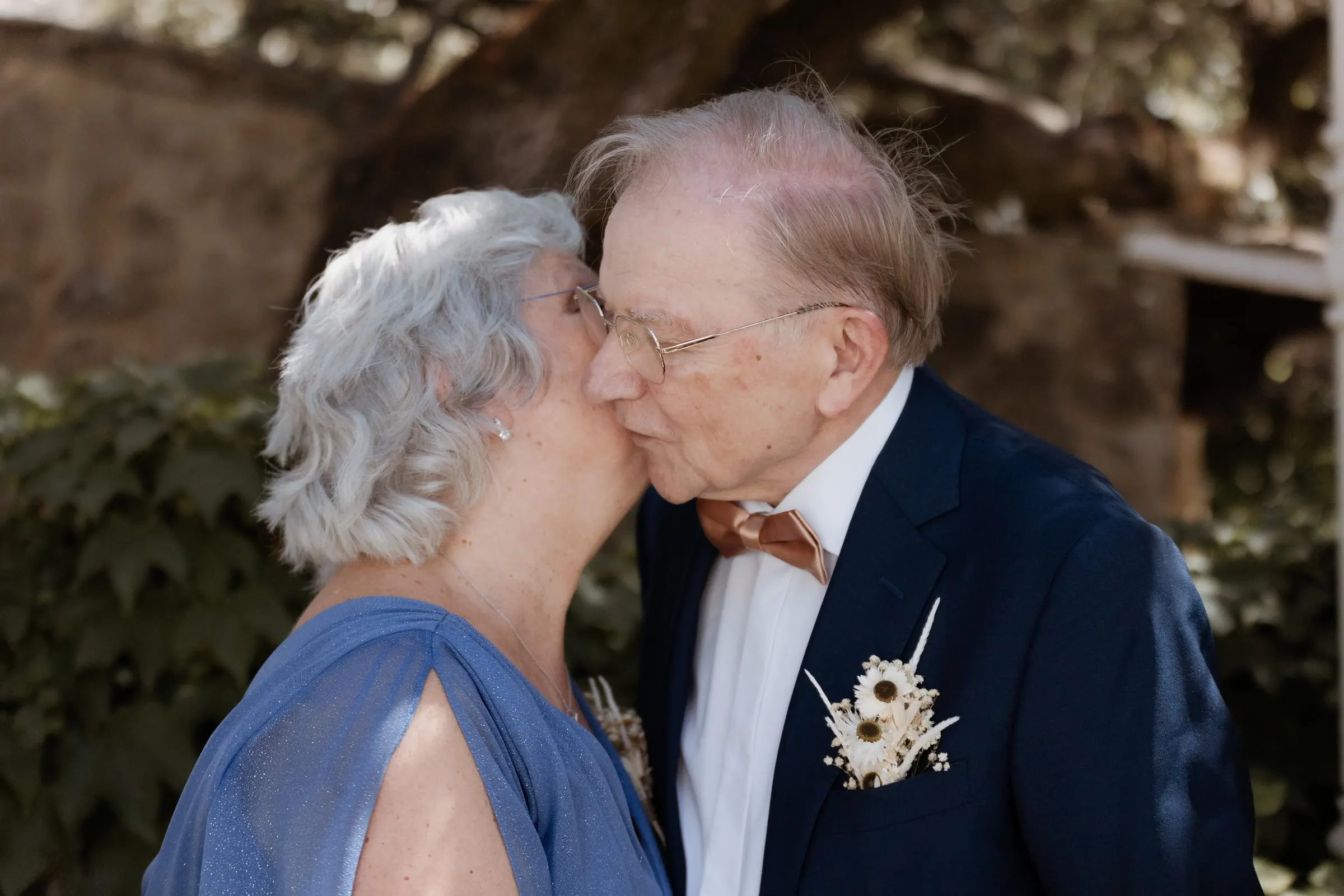 Older couple sharing a kiss in the garden before the ceremony in Ronda