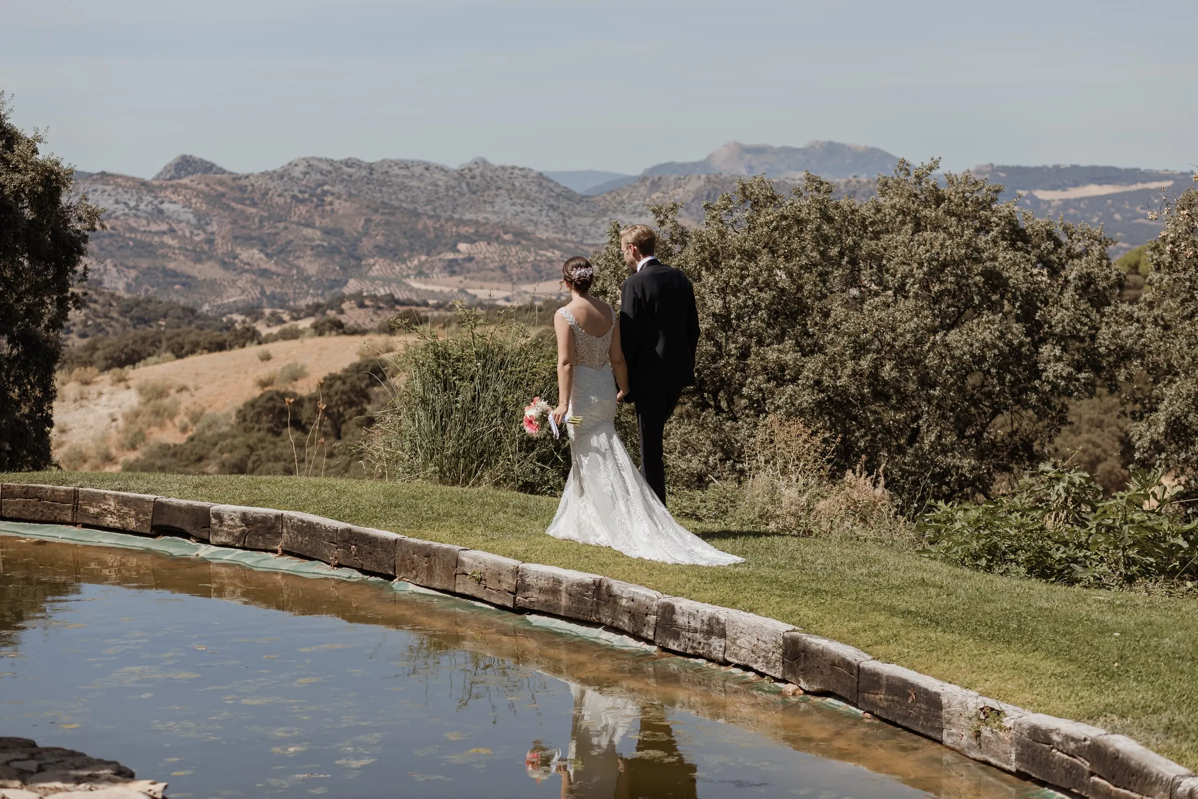 Couple by the pond looking out over the Serranía de Ronda mountains at Los Pilares de Ronda