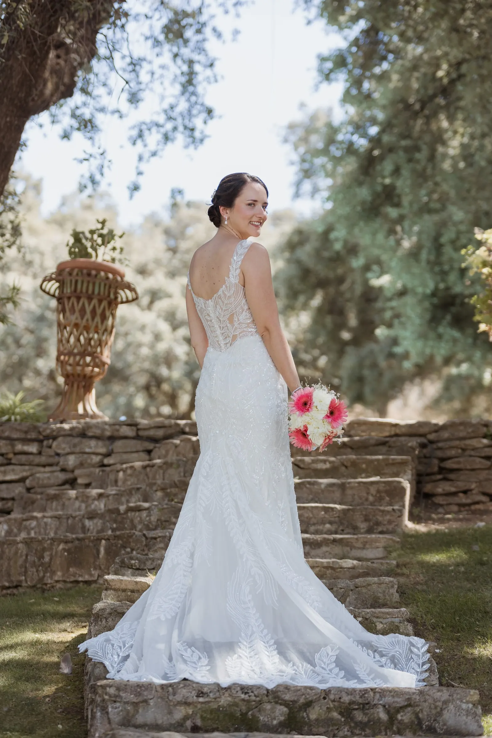 Bride from behind on the stone steps, showing the lace back and train