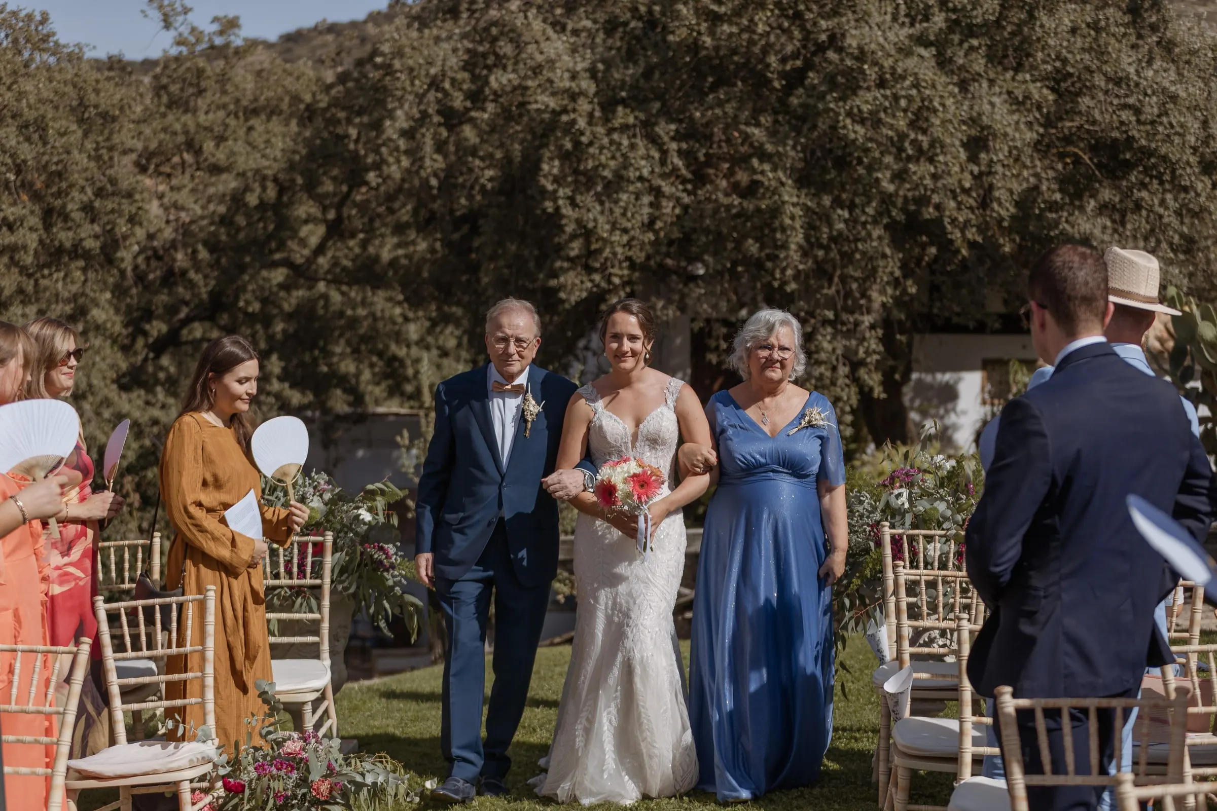 Bride walking down the aisle between her parents at Los Pilares de Ronda