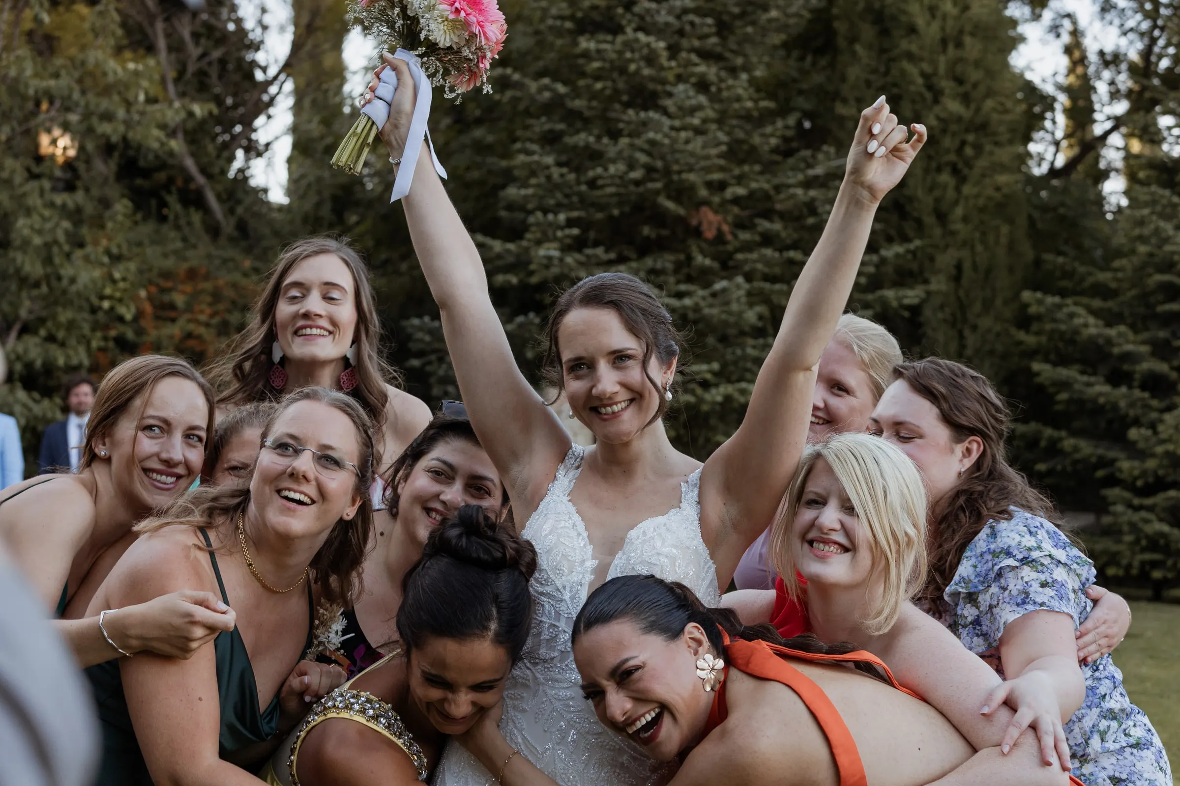 Bride's friends crowding around her with arms in the air in Ronda