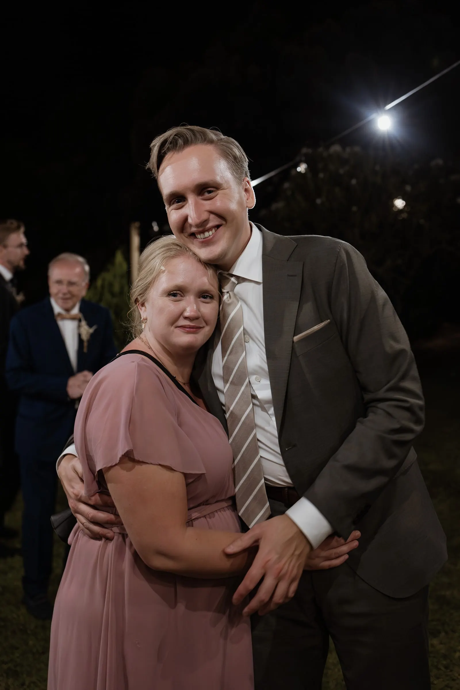 Guest couple hugging for a portrait on the dance floor at night