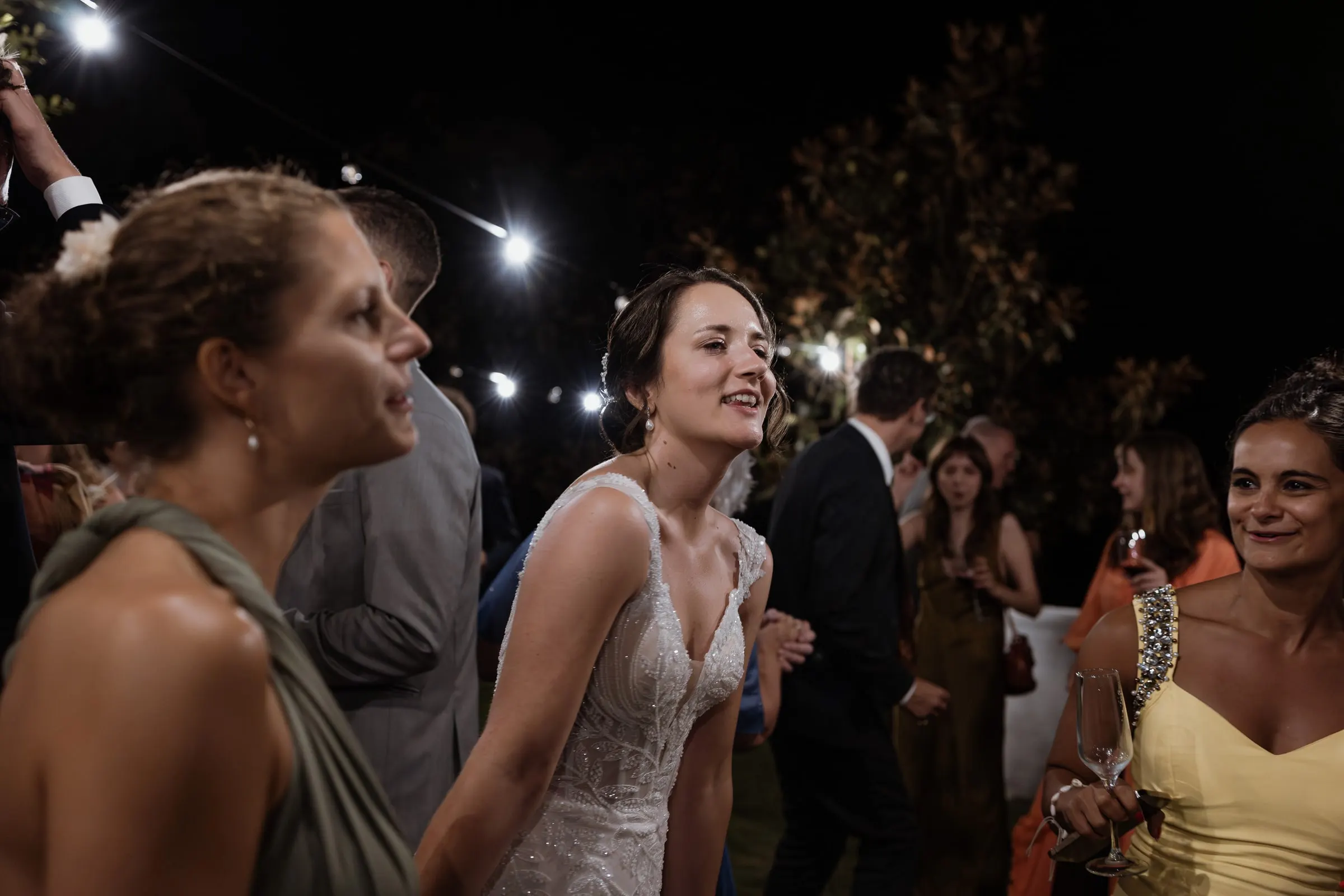 Bride dancing among her friends at night at Los Pilares de Ronda