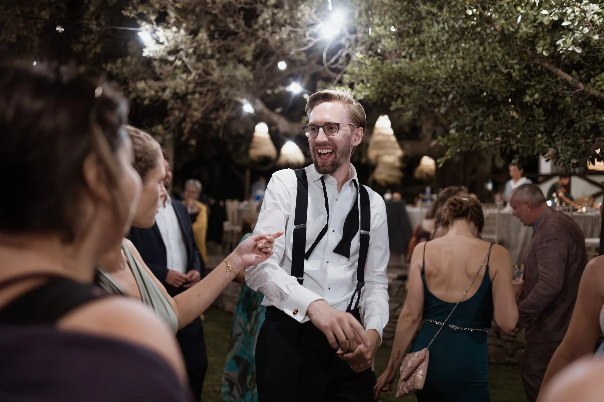 Groom in braces laughing on the dance floor
