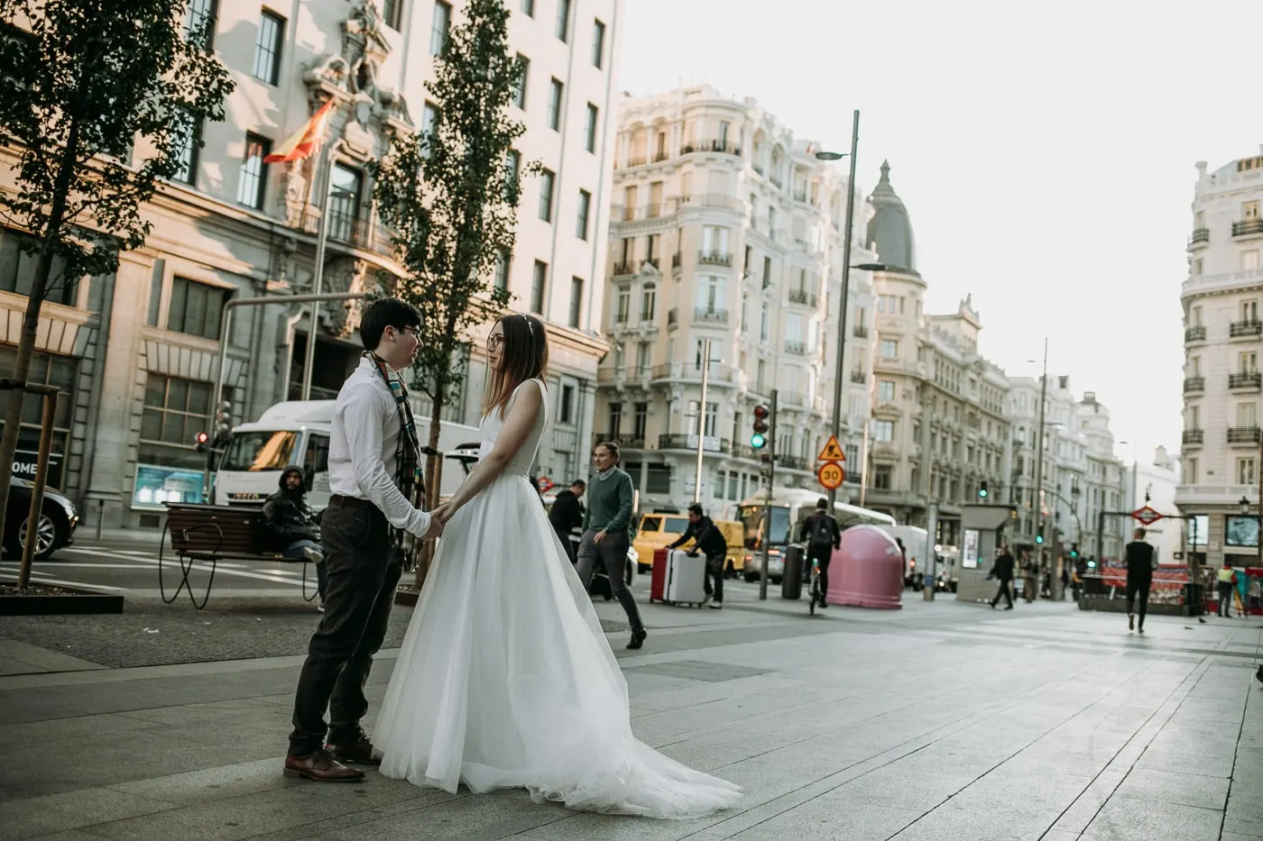 Bride and groom holding hands on a quiet stretch of Gran Vía, Madrid