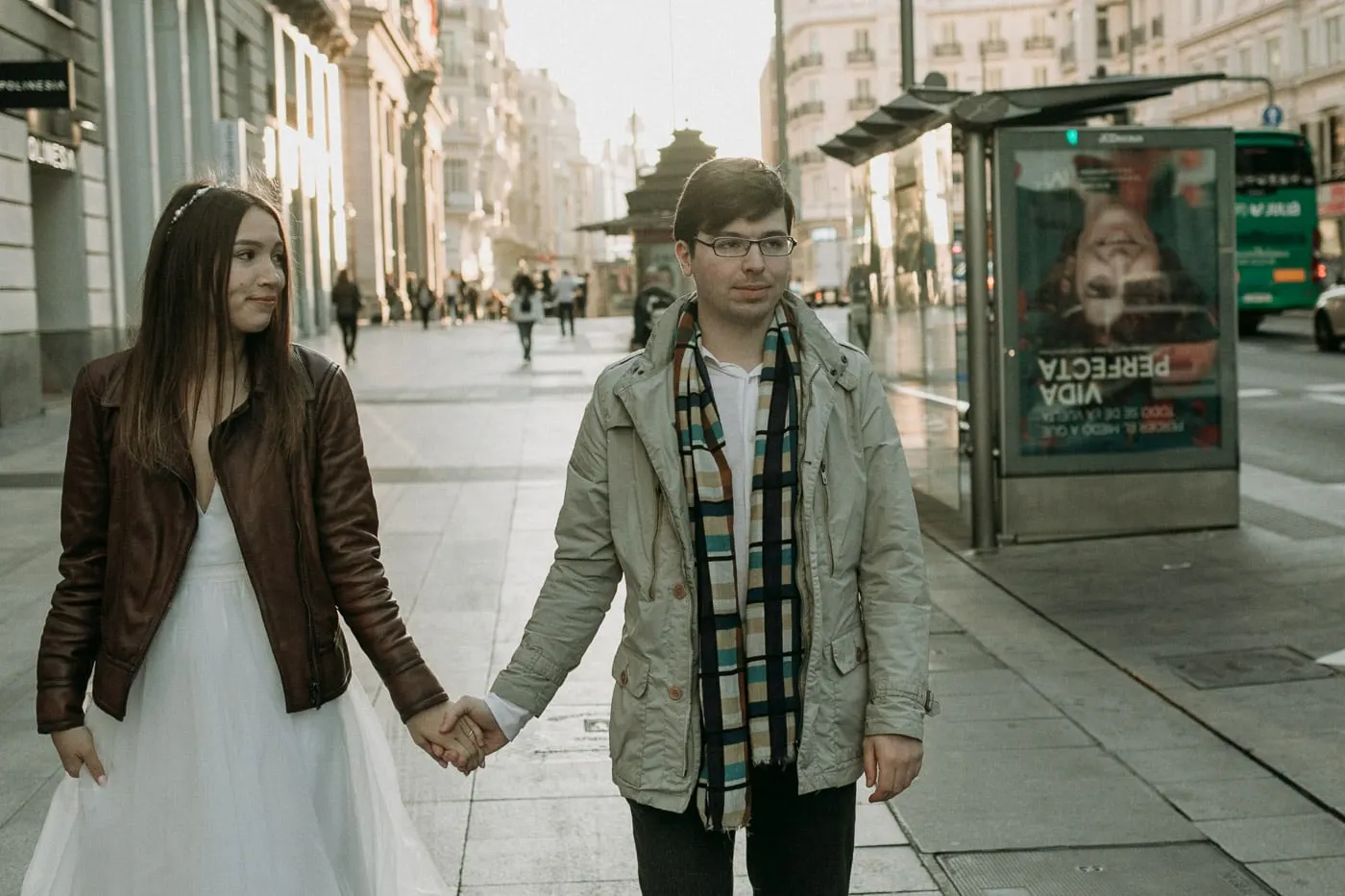 Couple walking in a leather jacket and a parka with a scarf, Madrid