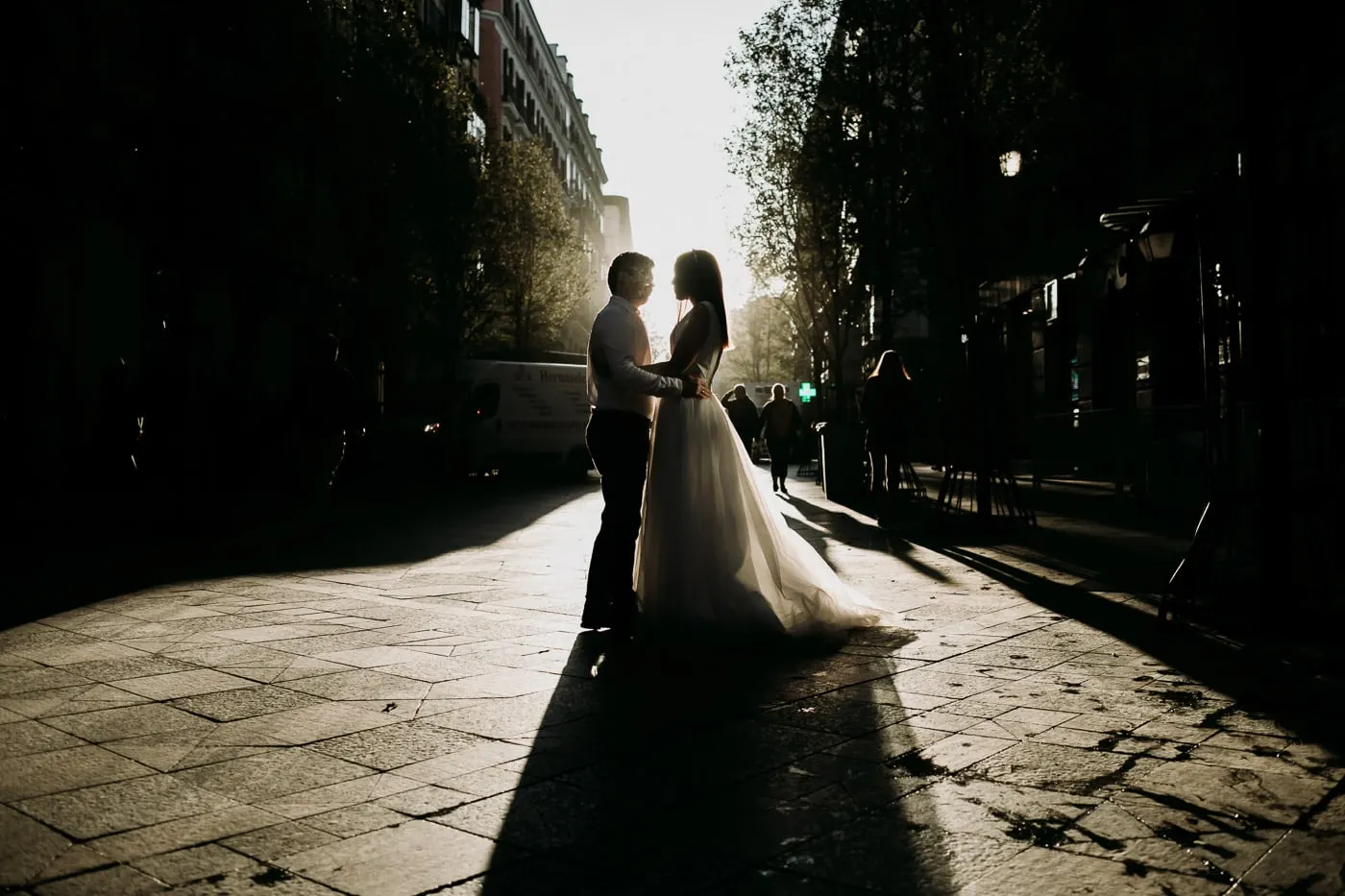 Silhouette of the couple on a paved street with long shadows