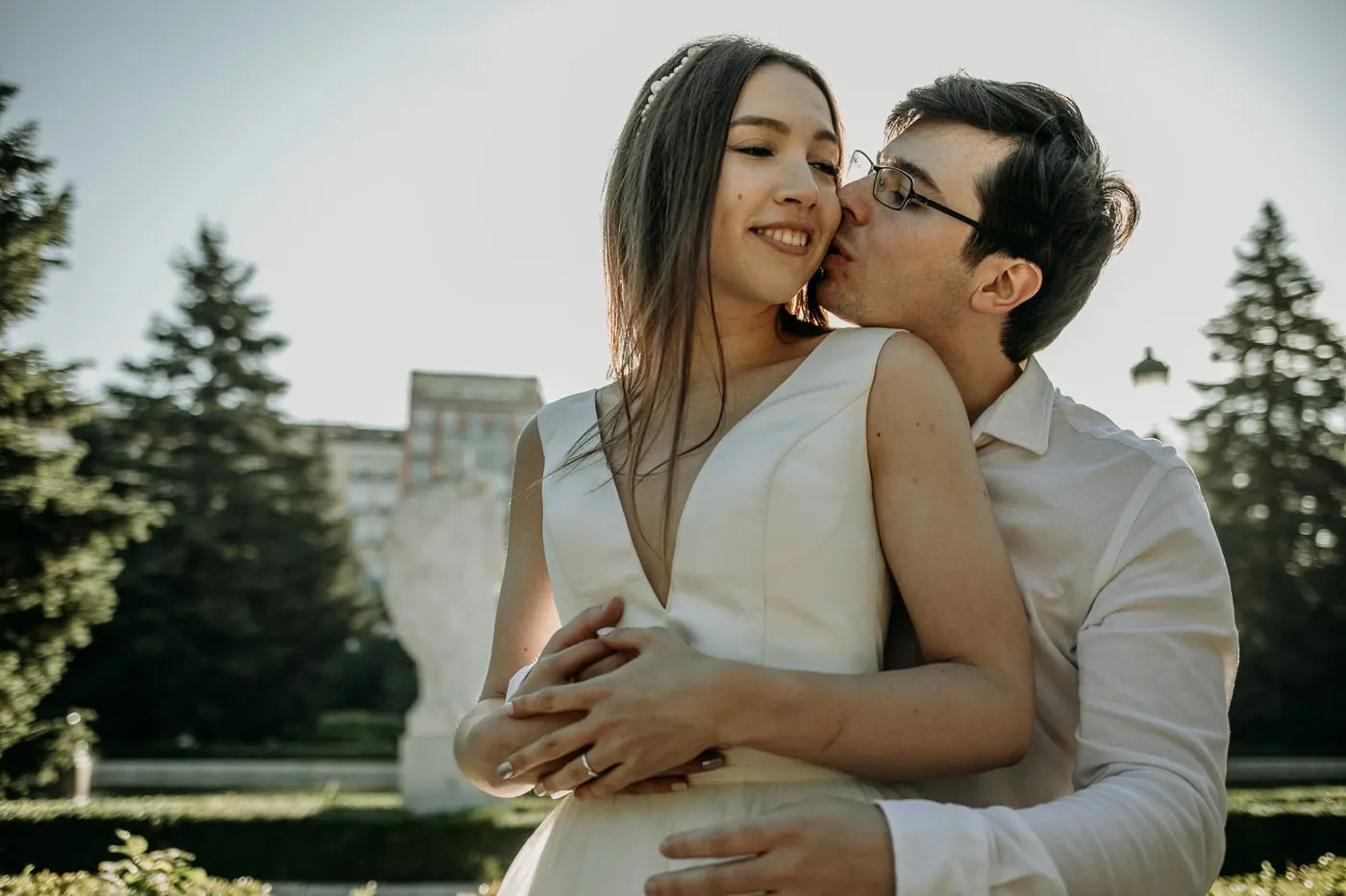 Groom kissing the smiling bride from behind