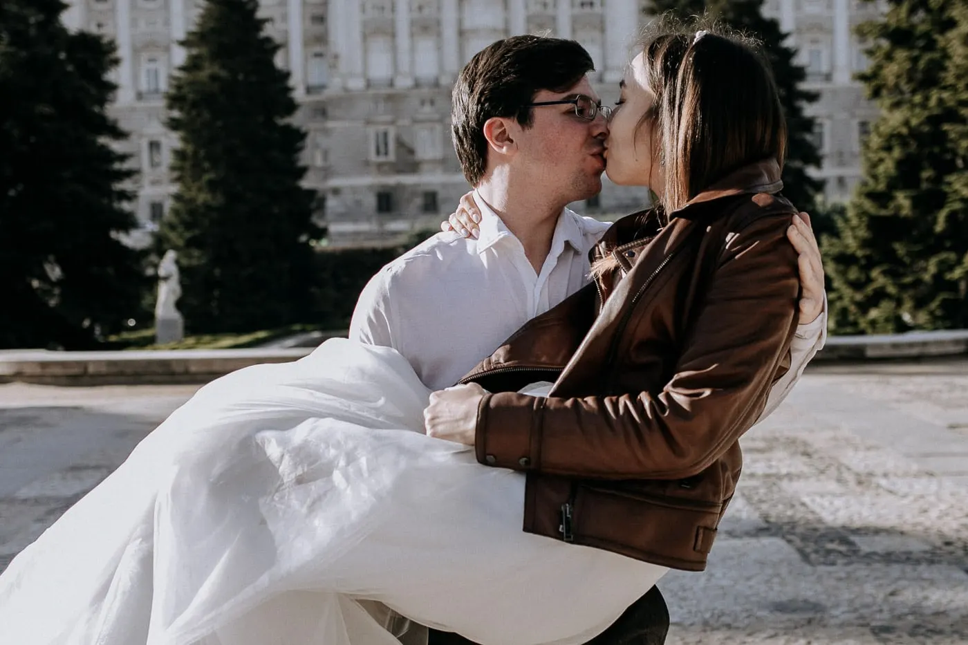 Groom kissing the bride as he holds her in his arms