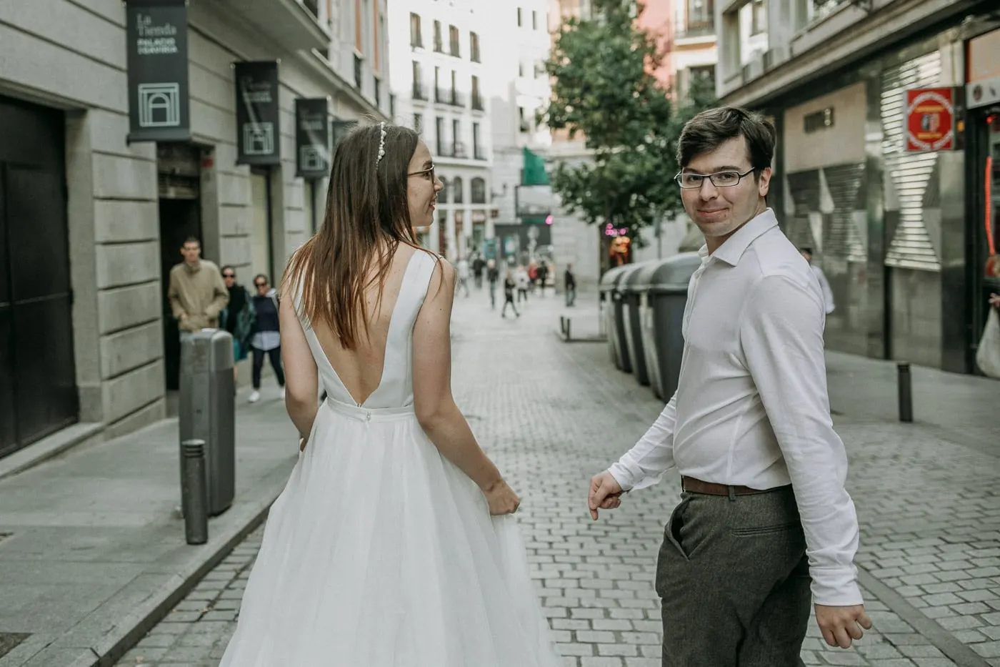 Bride and groom turning to look at each other on a pedestrian street