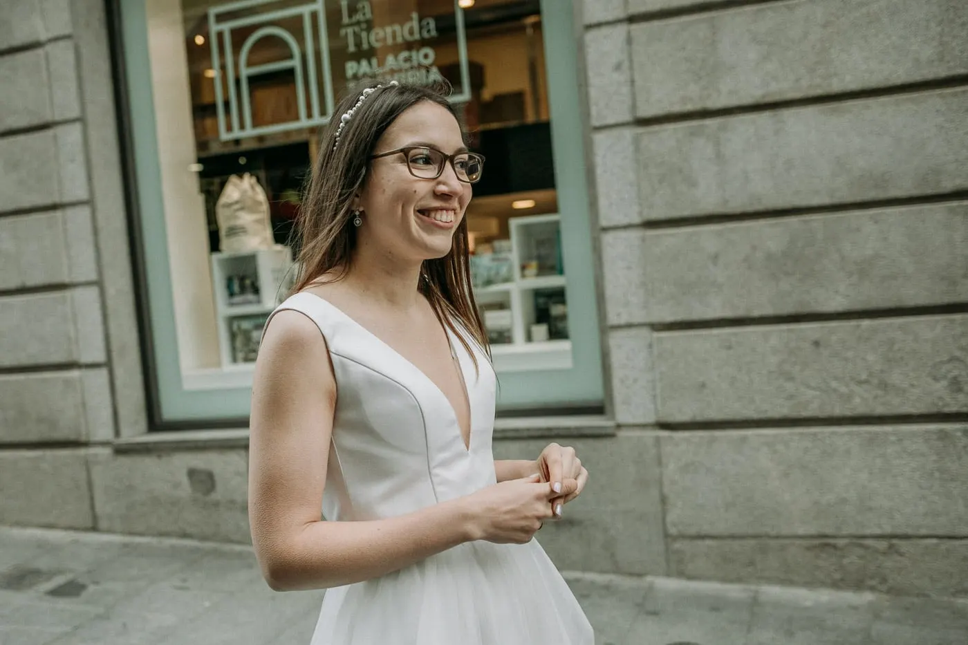 Bride laughing in front of a shop window in the old town