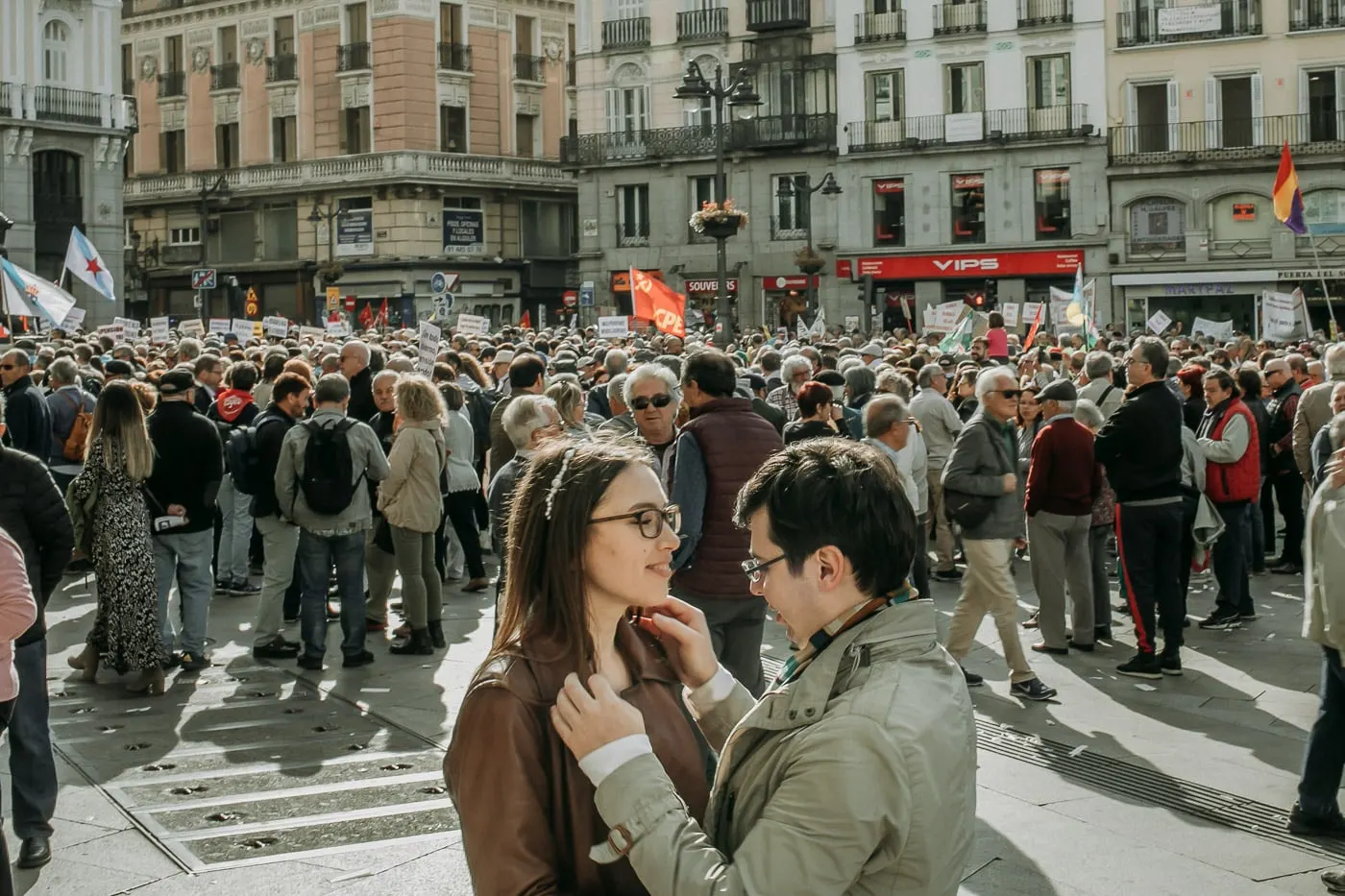 Couple sharing a quiet moment in a crowded square in the centre of Madrid