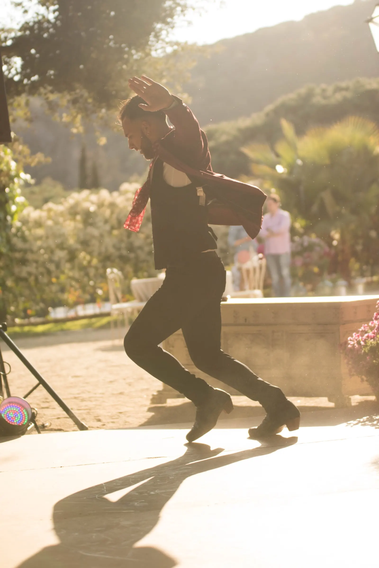A flamenco dancer stamping on the patio in golden backlight at a masia in Girona