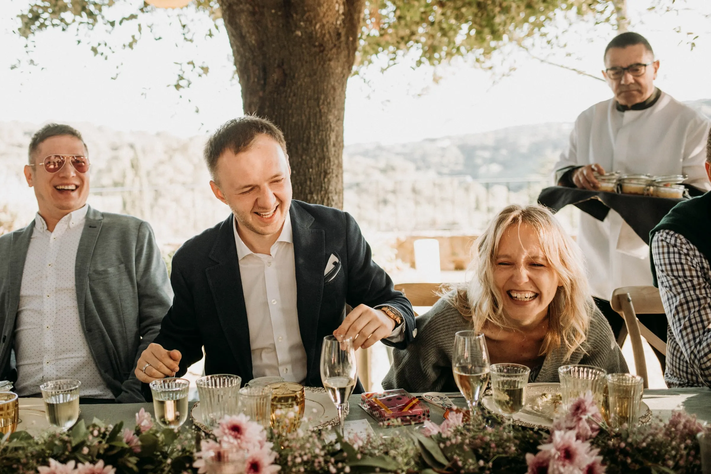 The groom and guests laughing out loud at the lunch table at a masia in Girona
