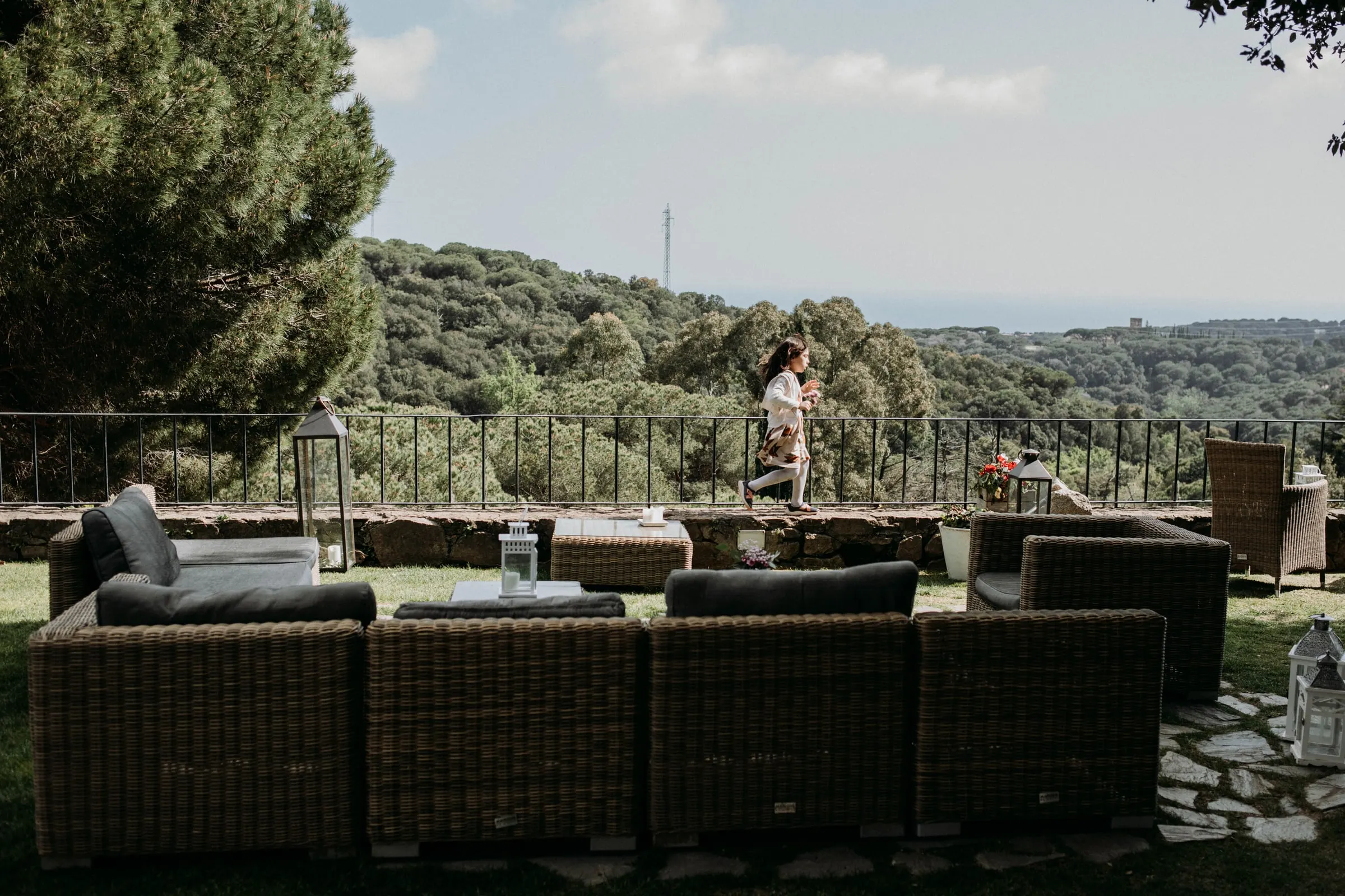 The wicker lounge set up on the garden terrace overlooking the hills of a masia in Girona