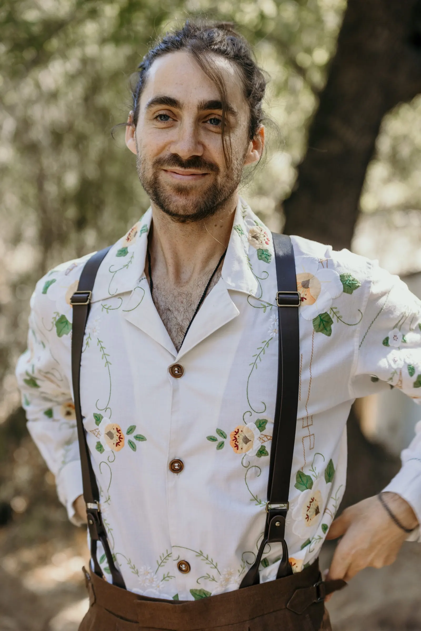 Smiling groom in braces and a hand-embroidered floral shirt in the Serranía de Ronda