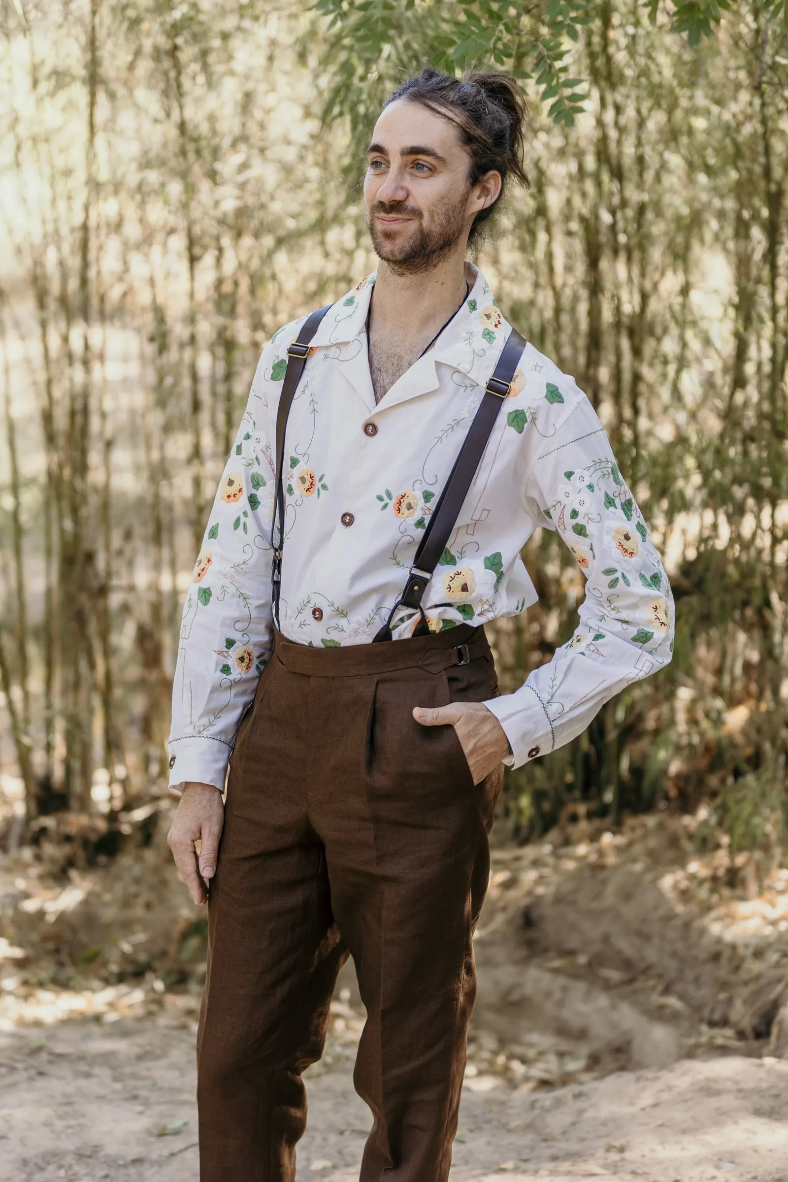 Groom with a hand on his hip in front of tall reeds at Molino La Flor